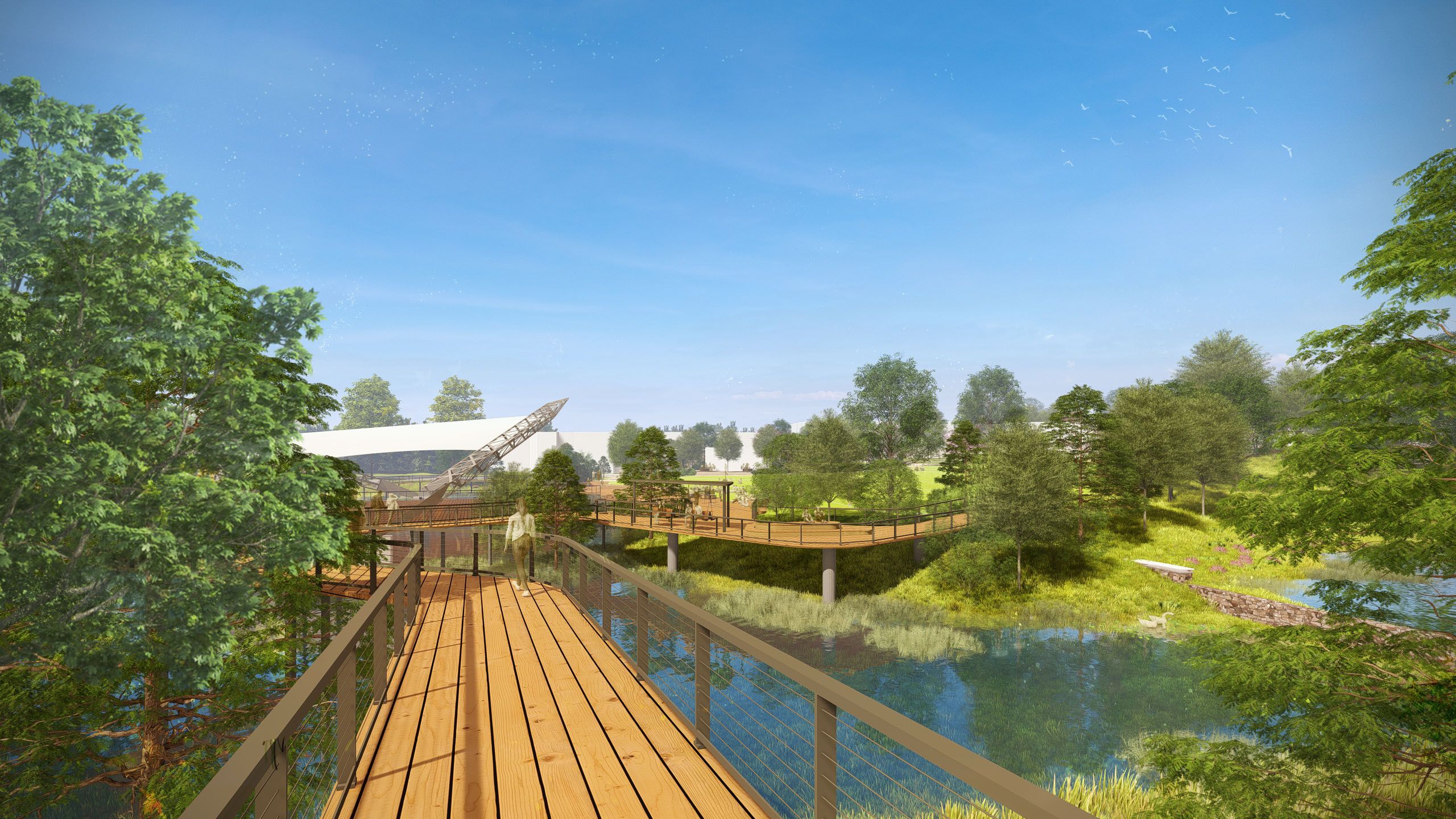 Wooden boardwalk over a pond in a green park with trees and blue sky, people walking and sitting on benches, and a white canopy structure in the background.