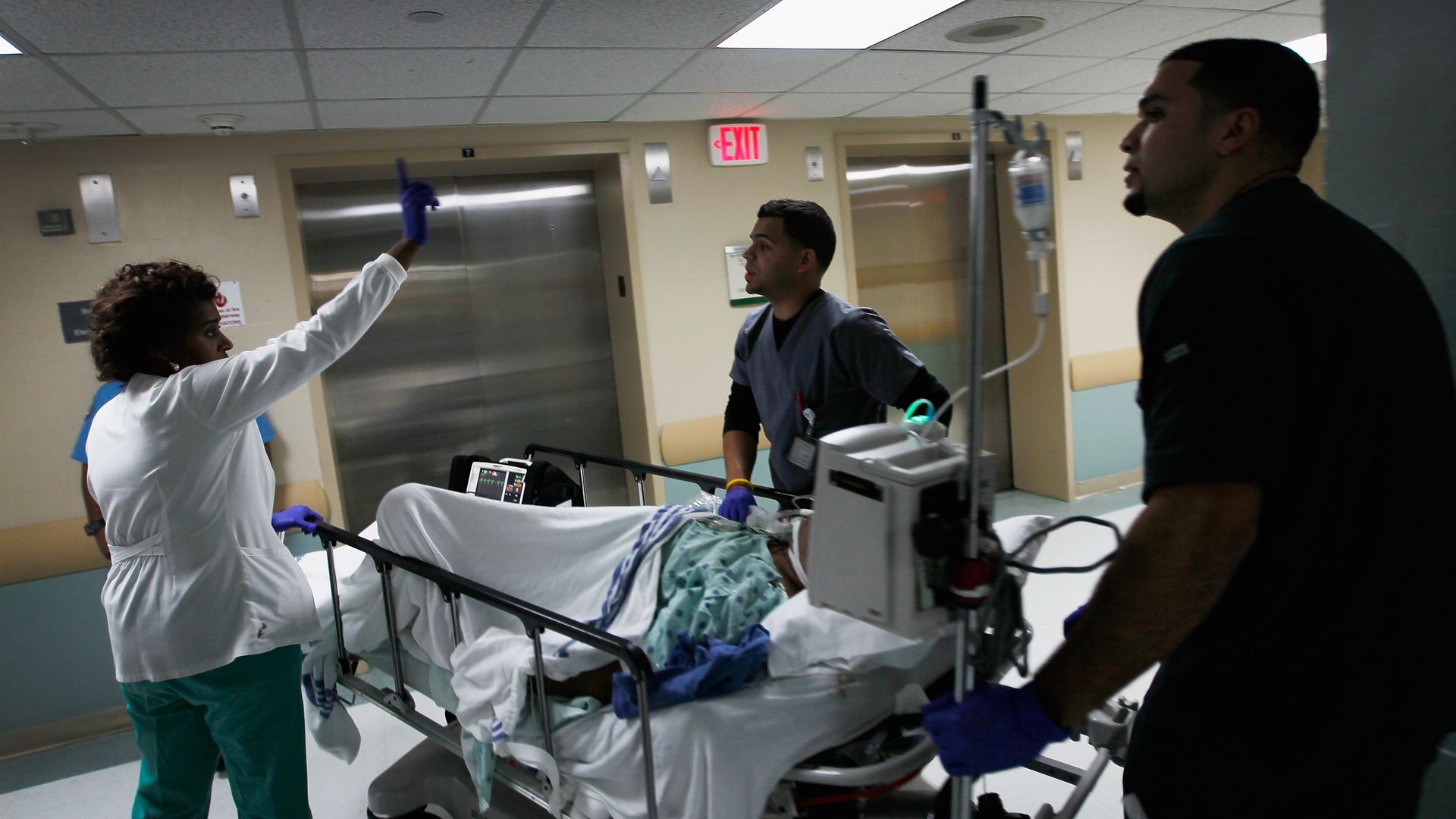 Nurses pushing hospital bed down hallway