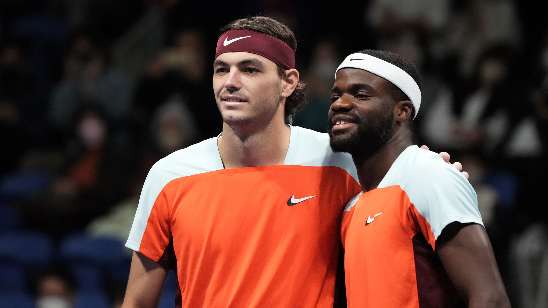 Taylor Fritz and Frances Tiafoe pose for a picture together on a tennis court.