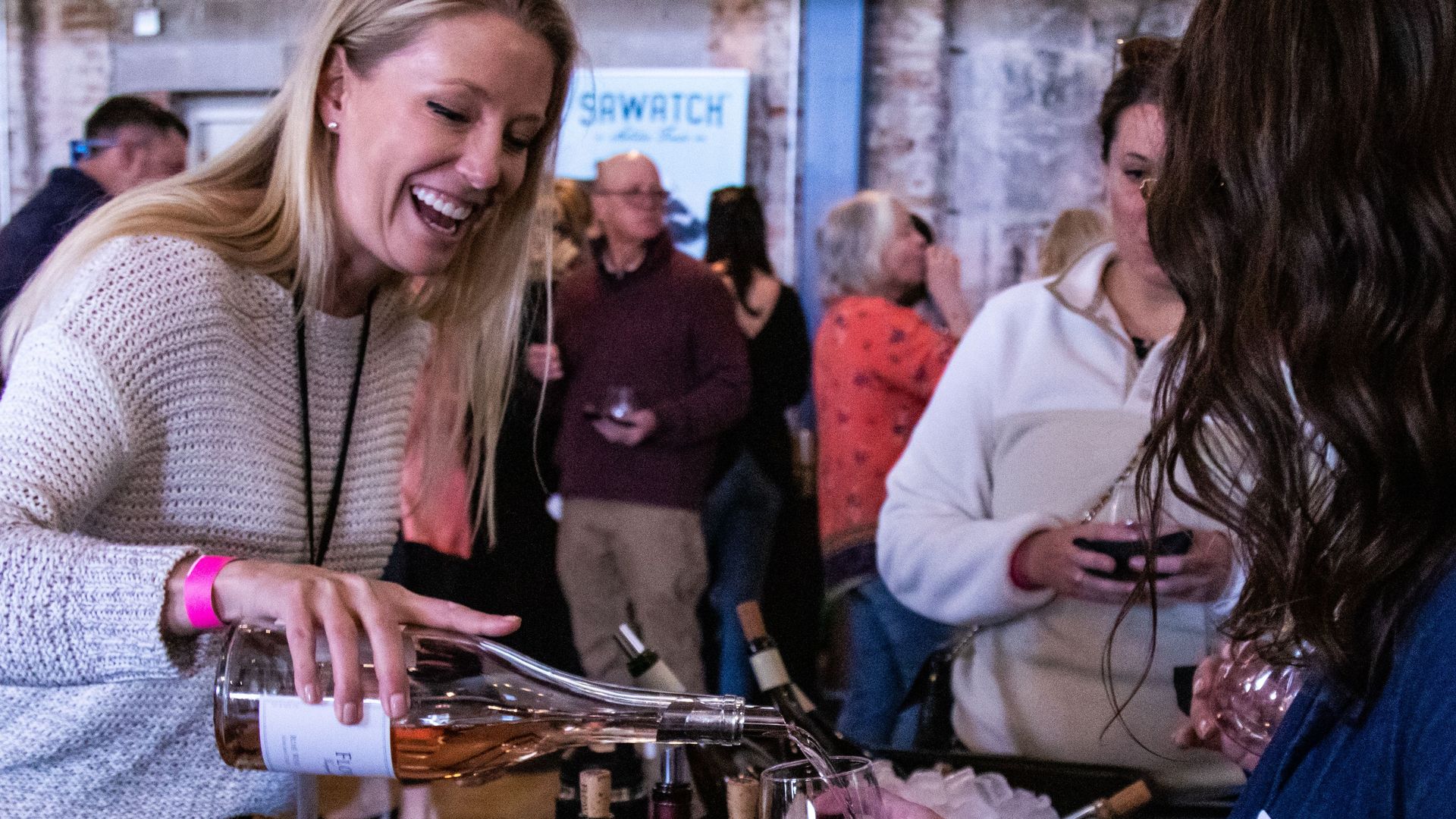 Woman pouring a glass of wine for an attendee of the Big Stir Festival in Denver, Colorado