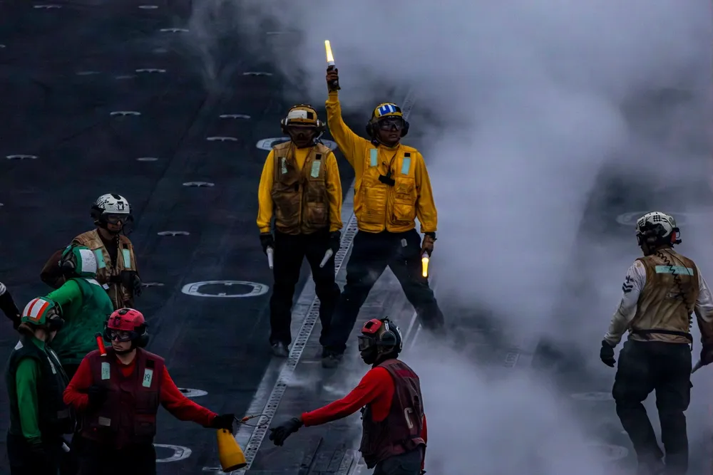 A U.S. Sailor directs aircraft on the flight deck of Nimitz-class aircraft carrier USS Abraham Lincoln (CVN 72), Aug. 14, 2026. Abraham Lincoln is deployed to the U.S. 5th Fleet area of operations to support maritime security and stability in the Middle East. (U.S. Navy photo)