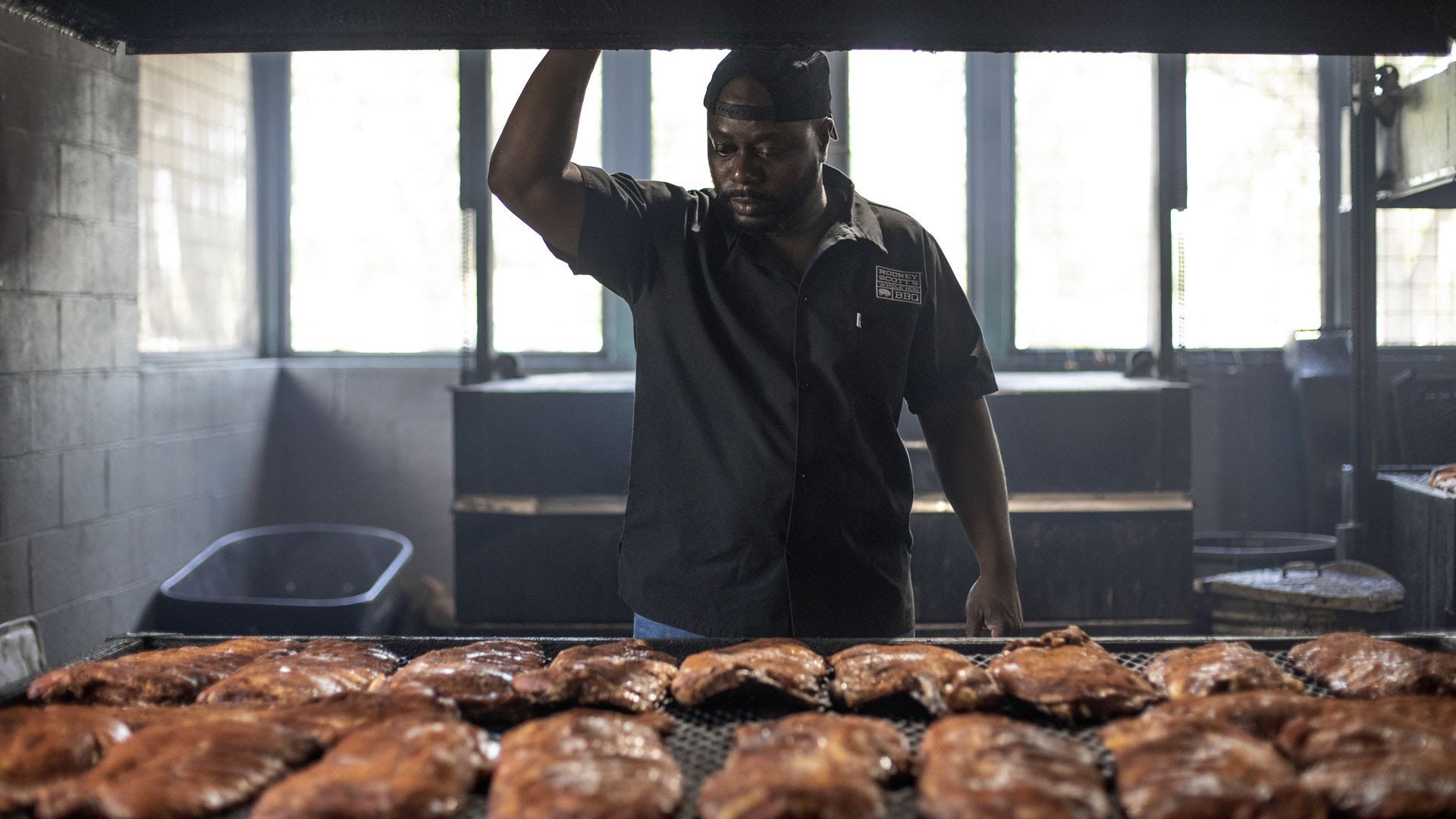 Rodney Scott checks racks of ribs as they cook. 
