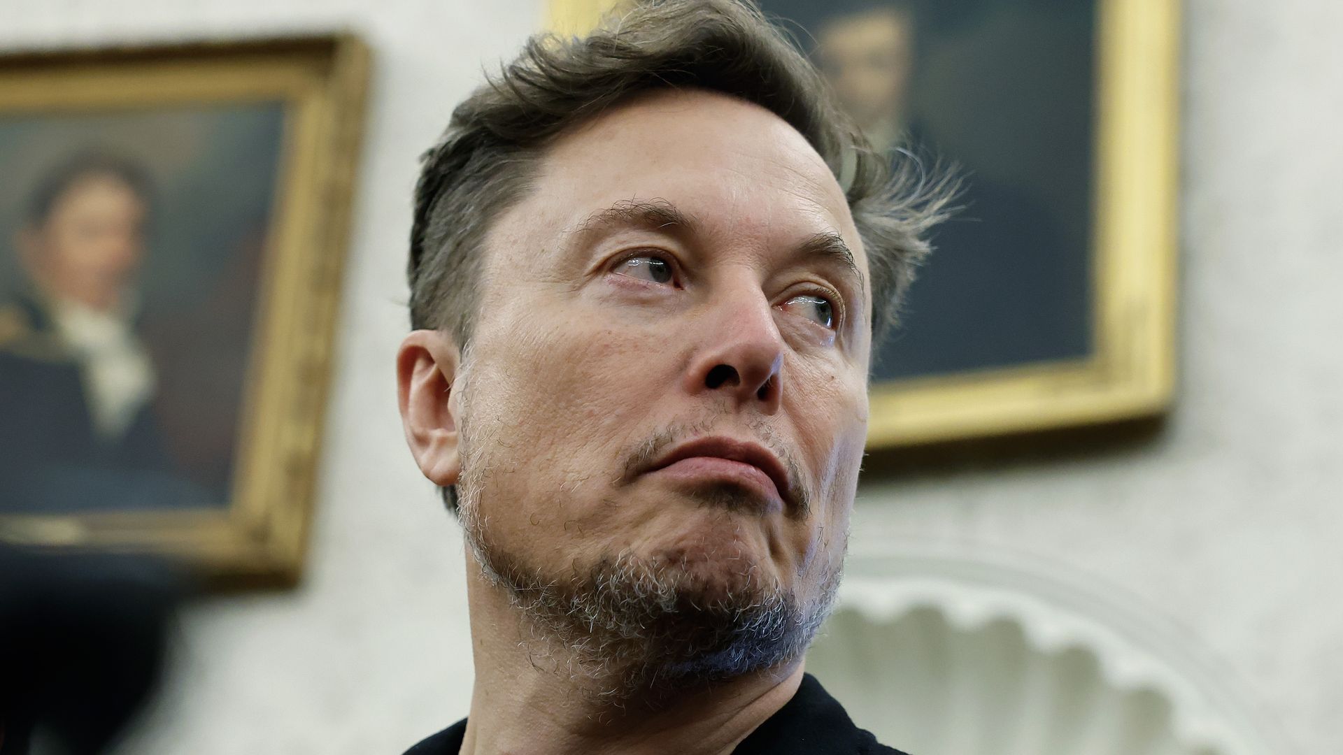 Elon Musk listens as reporters ask questions during a press availability in the White House.