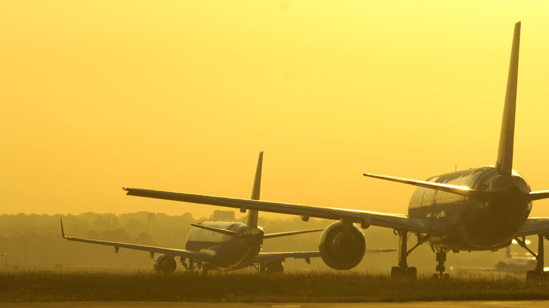 Airplanes taxi waiting for takeoff from an airport.