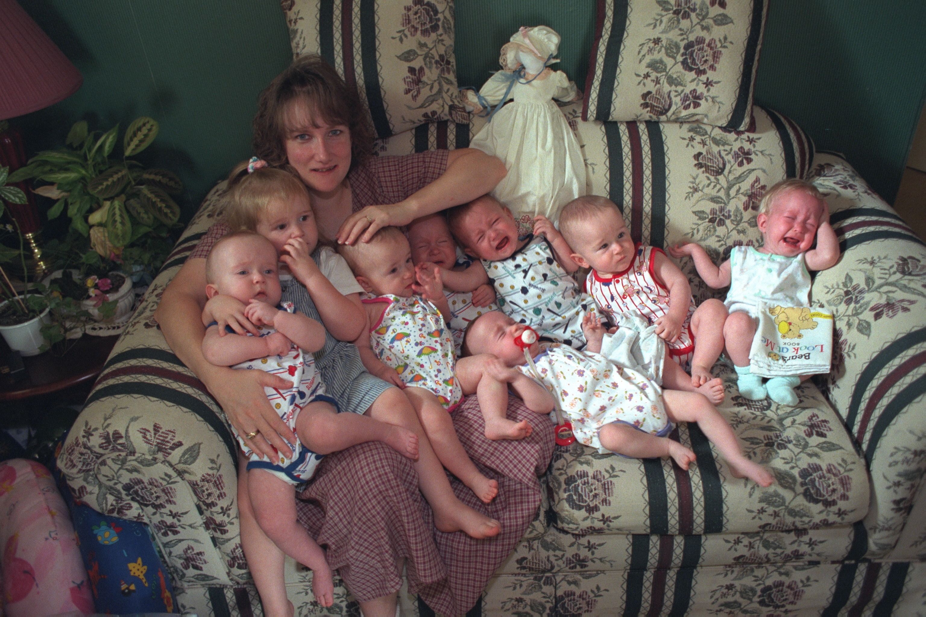 A mom and her septuplets on a couch