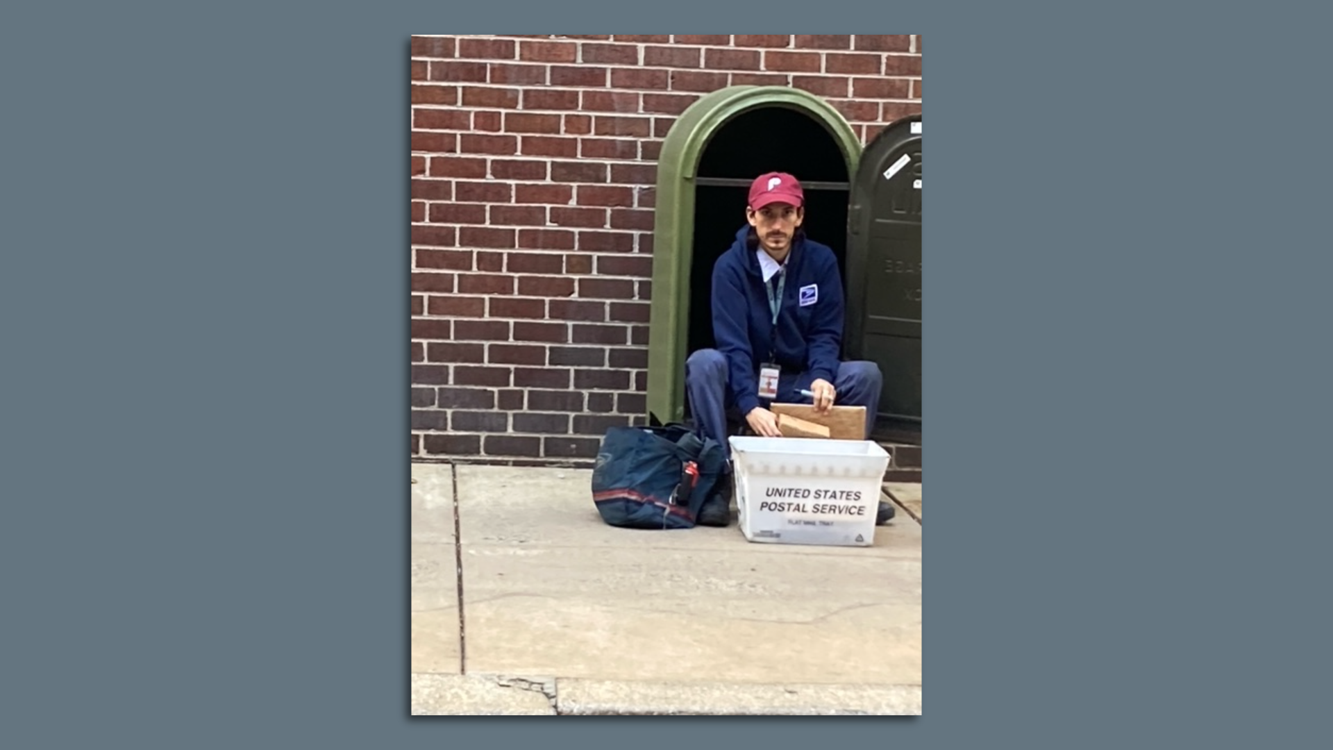 Mail man sports Phillies hat during team's race for the NL pennant.