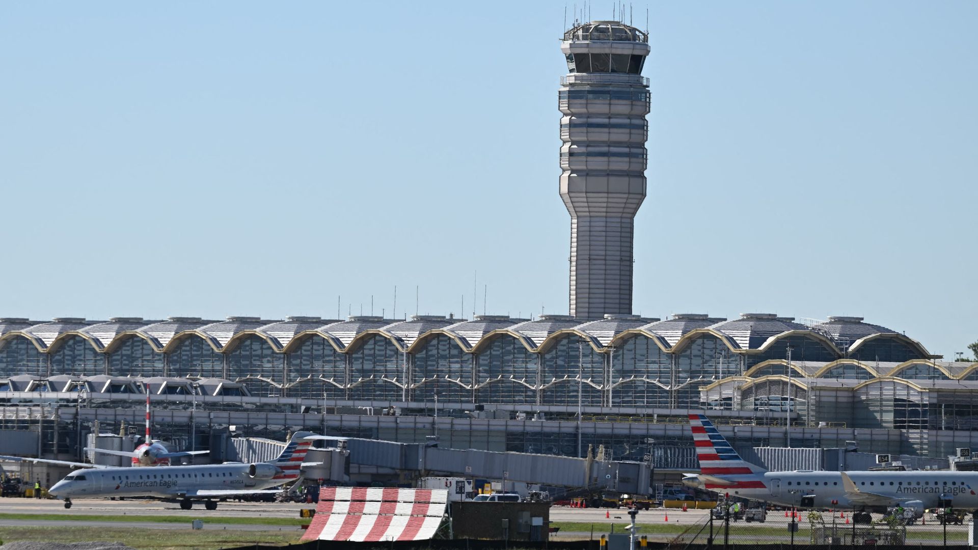 A view of the control tower at Ronald Reagan Washington National Airport as 2 planes sit on the runway on October 9, 2025, in Arlington, Virginia.