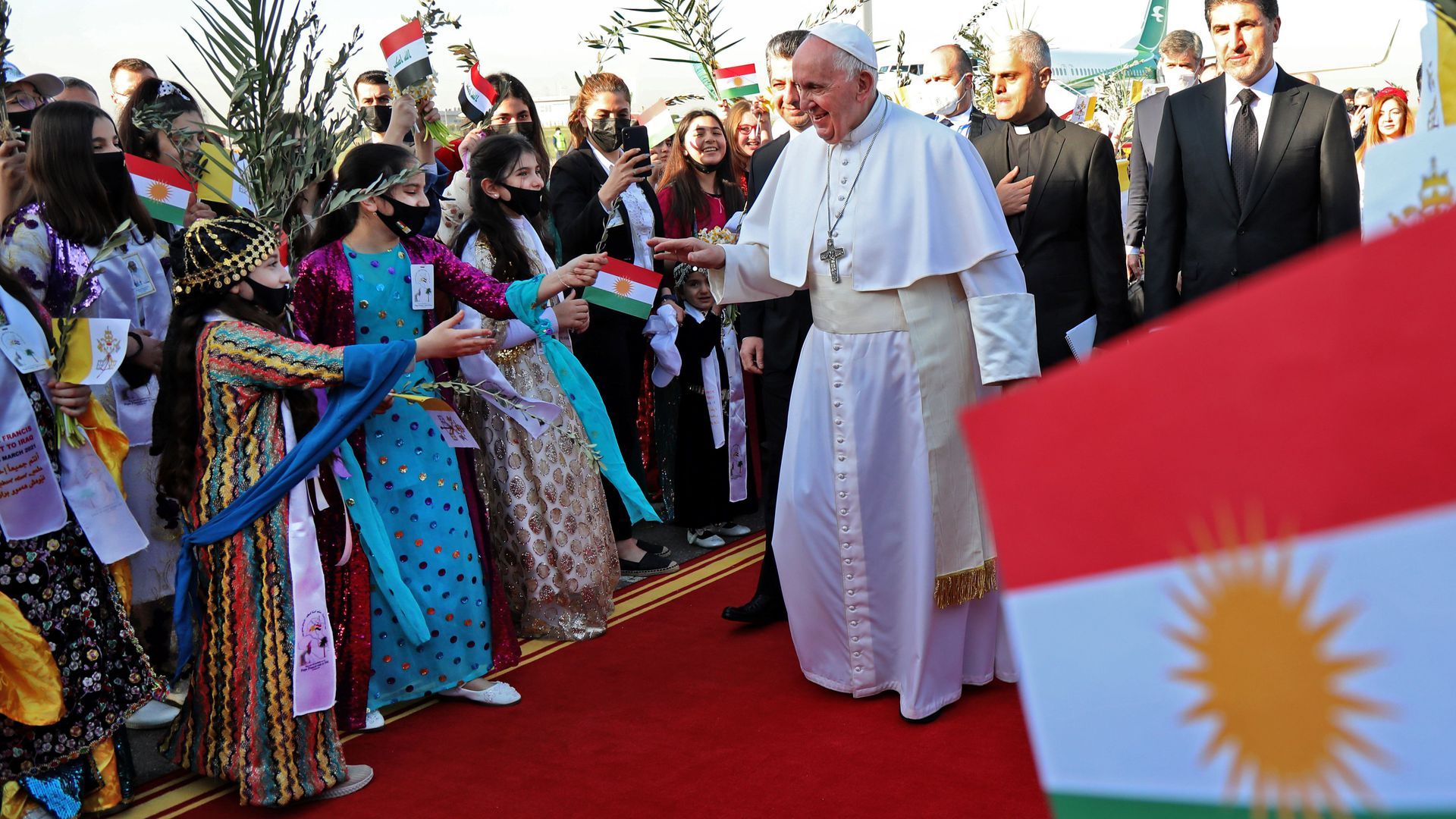 Iraqis dressed in traditional outfits greet Pope Francis upon his arrival at Erbil airport, the capital of the northern Iraqi Kurdish autonomous region, on March 7. 