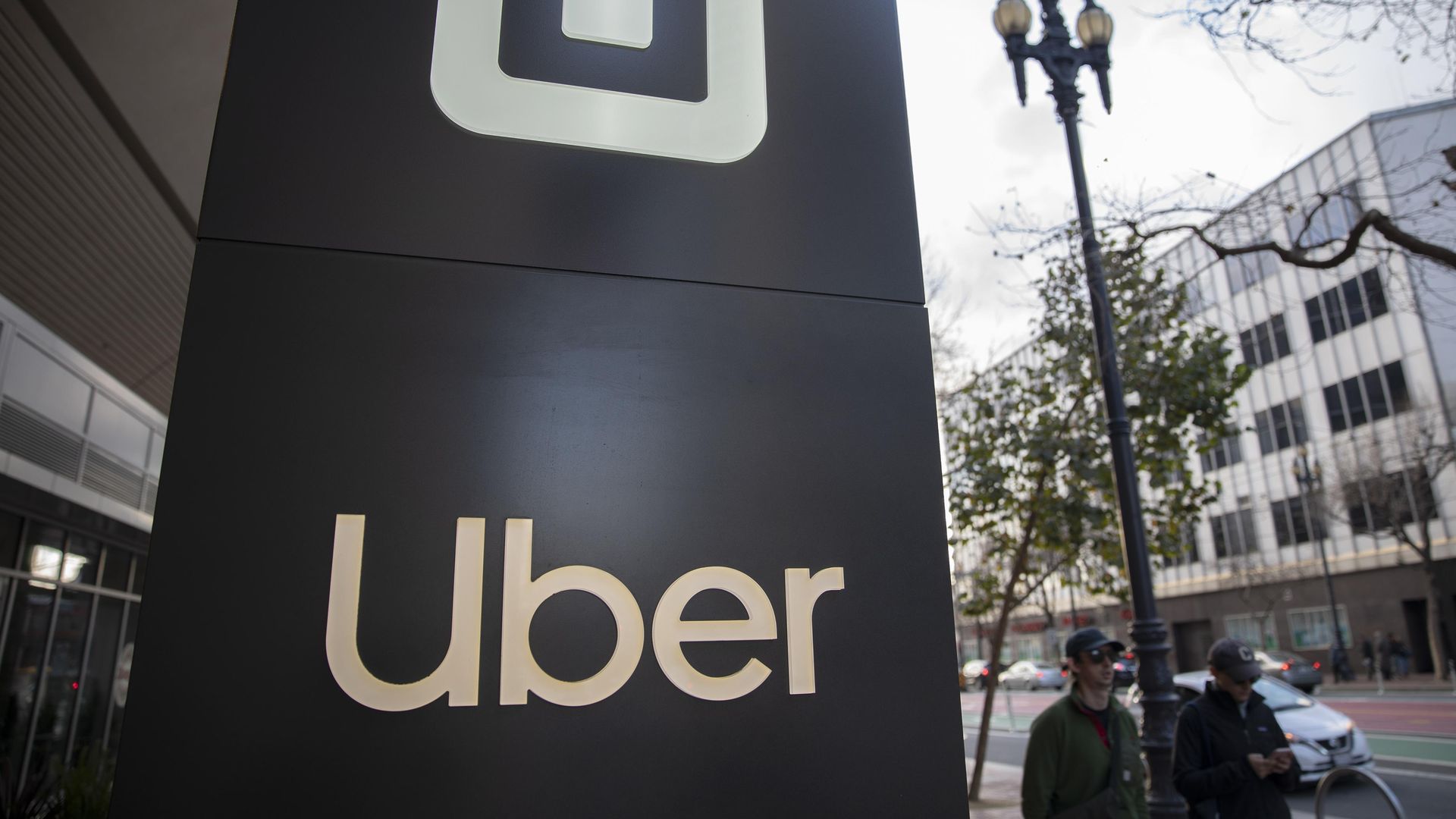 Pedestrians walk past a signage displayed outside Uber Technologies headquarters on January 12, 2020 in San Francisco, California. 
