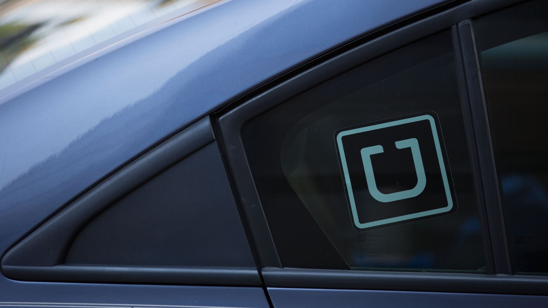 A car has an Uber sticker on its window