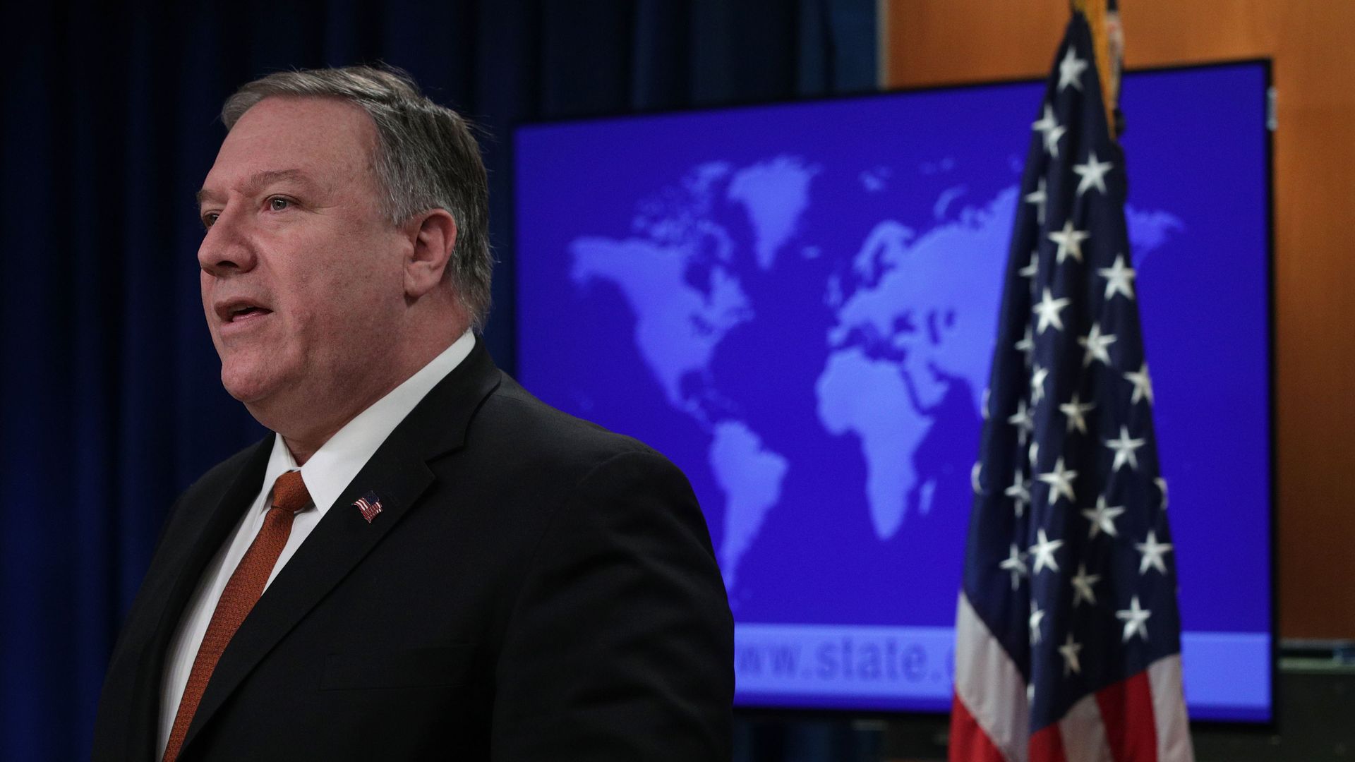 Secretary of State Mike Pompeo stands next to the American flag.