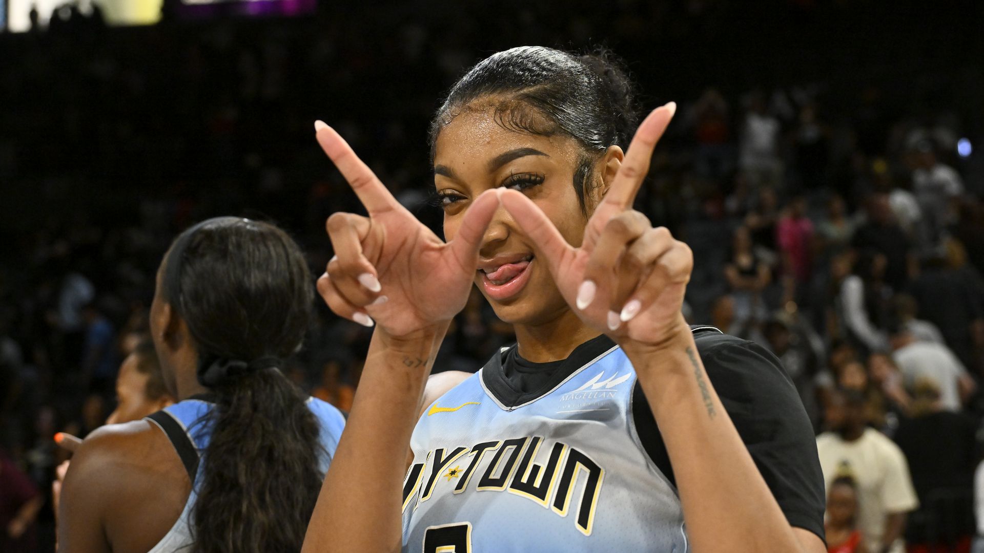 Photo of a basketball player using a "win" hand gesture 