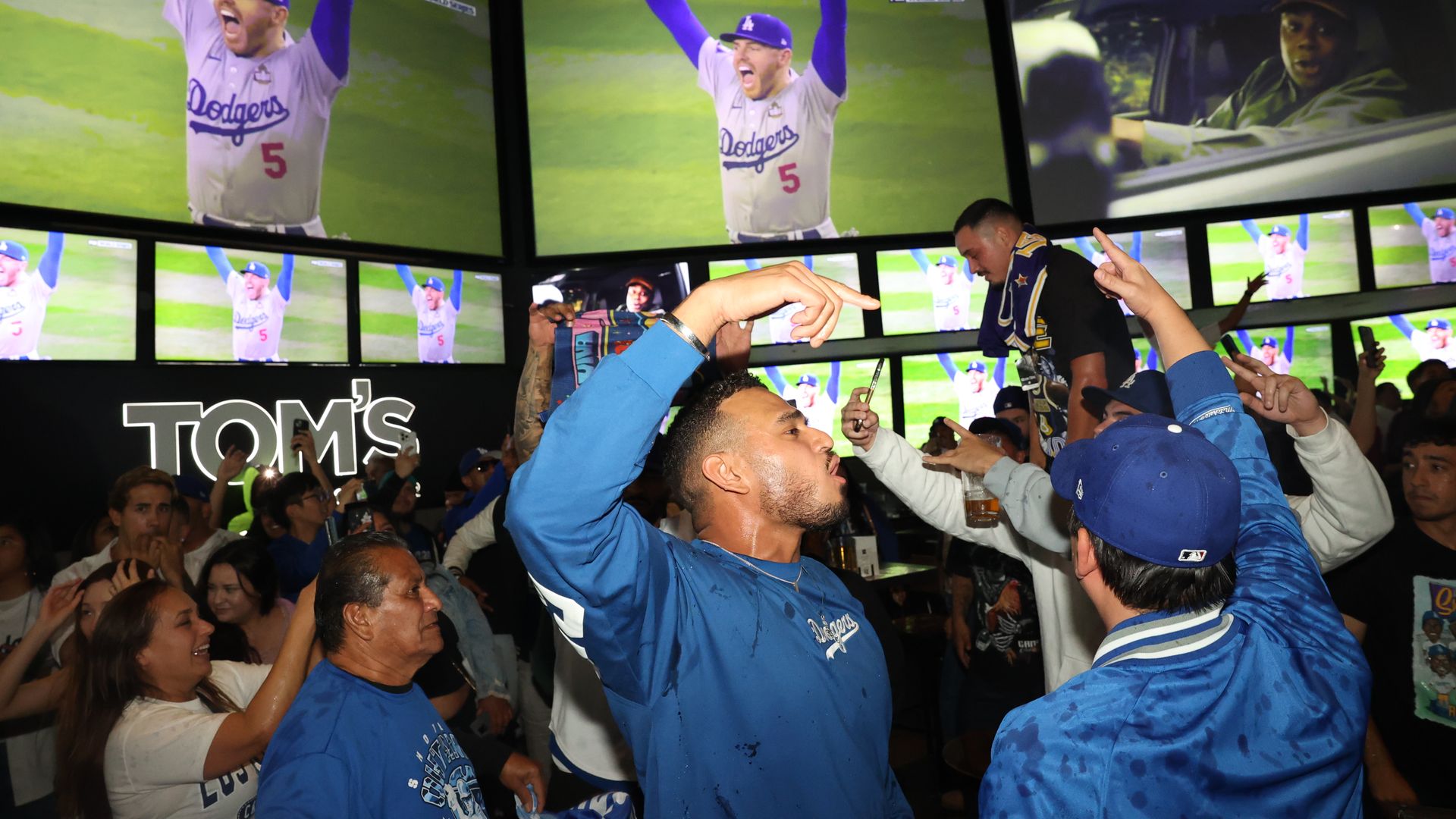 Fans celebrate their team's victory at a Tom's Watch Bar location.