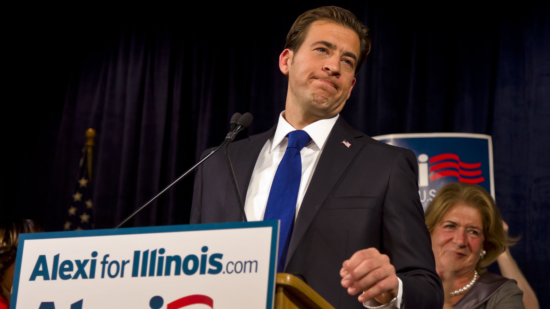 A photo of a man behind a podium.