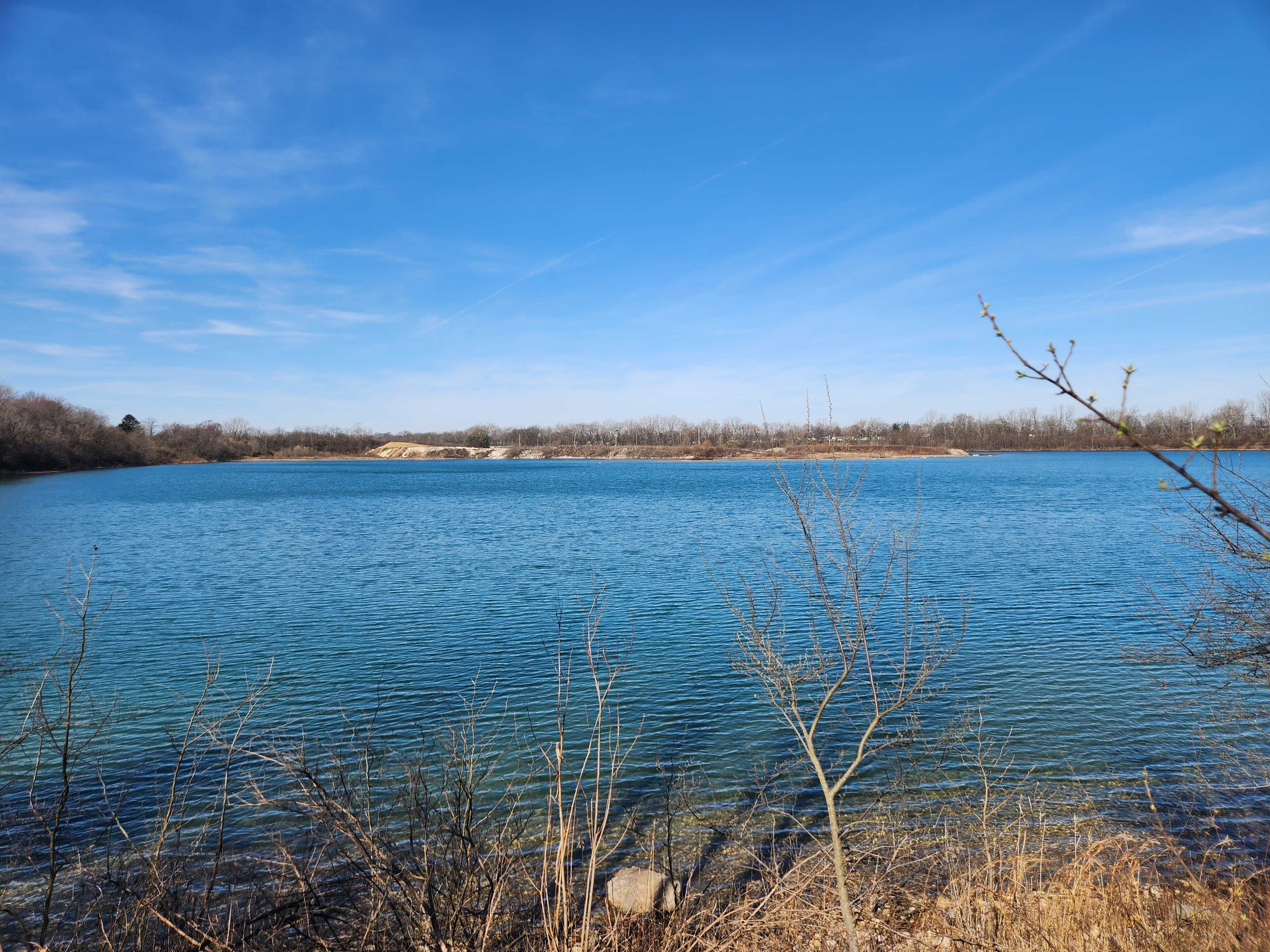 A view of a lake with some branches in the foreground.