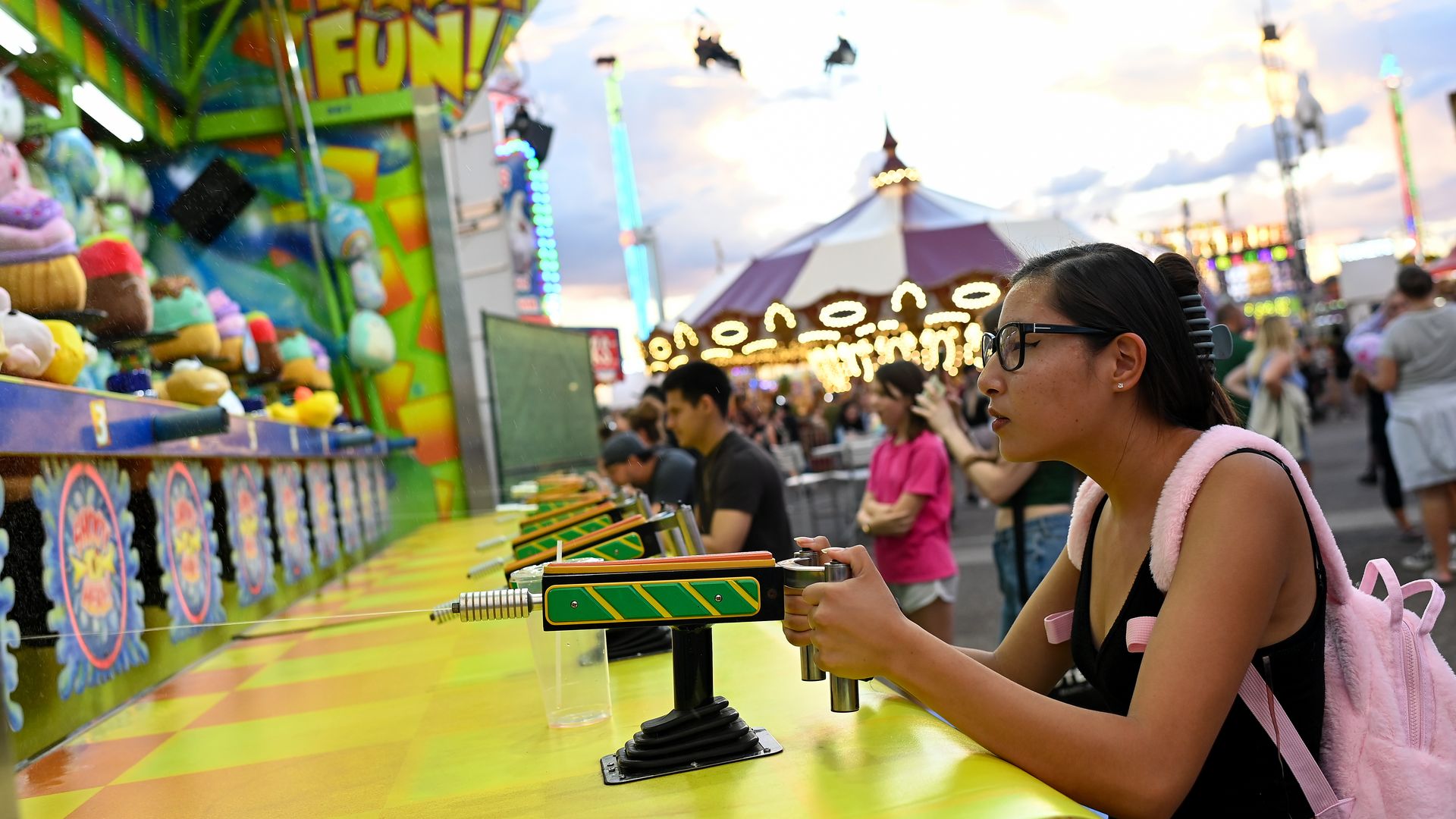 A woman playing a carnival game.