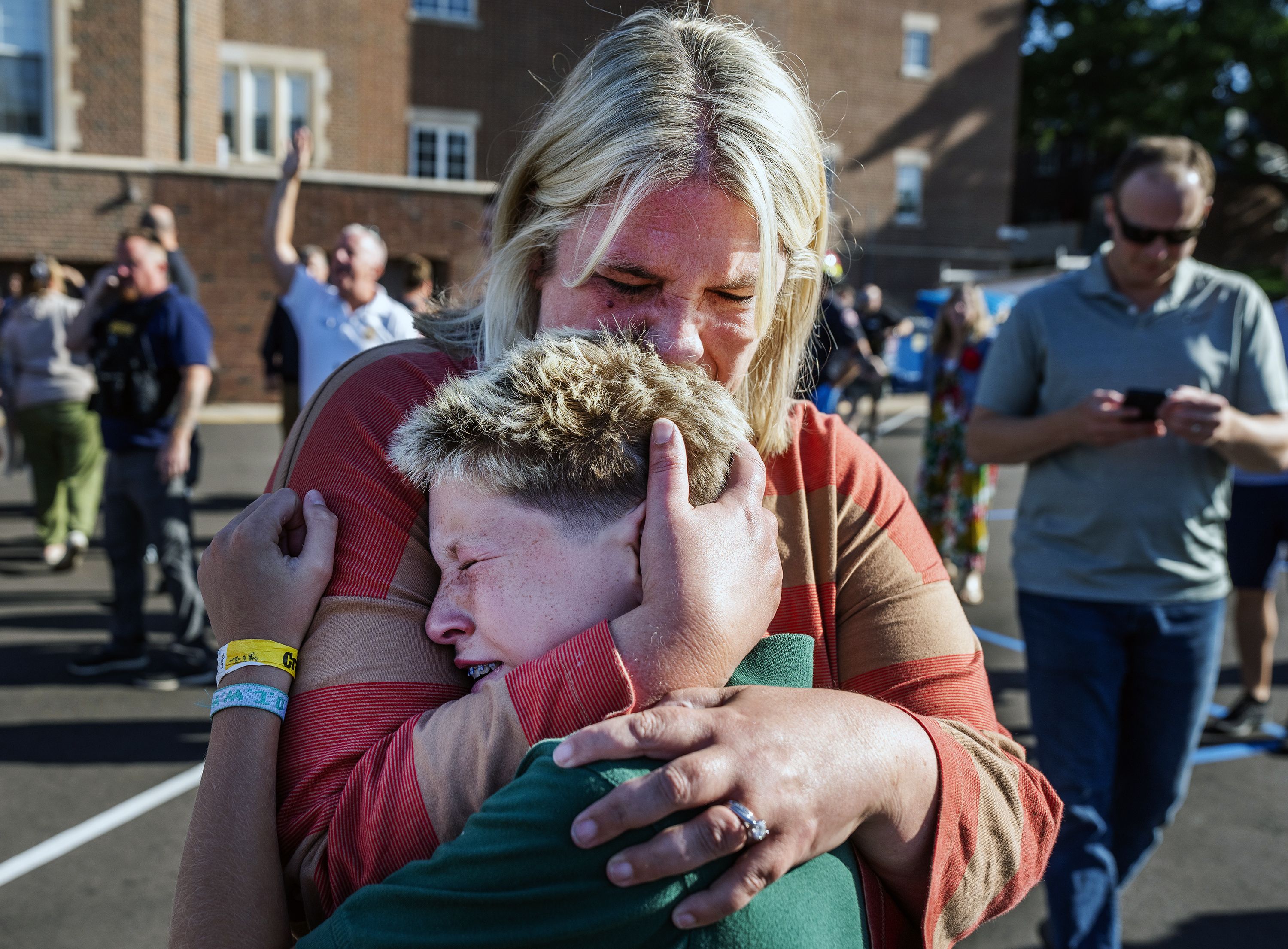 A mom hugs her son after a shooting at Annunciation Church in Minneapolis.