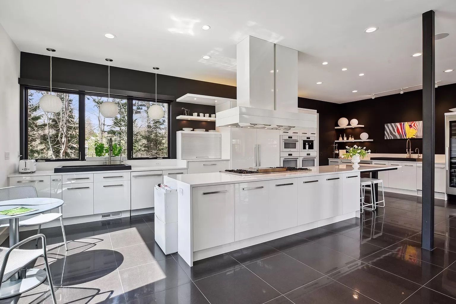 A large kitchen with black walls and white cabinets.