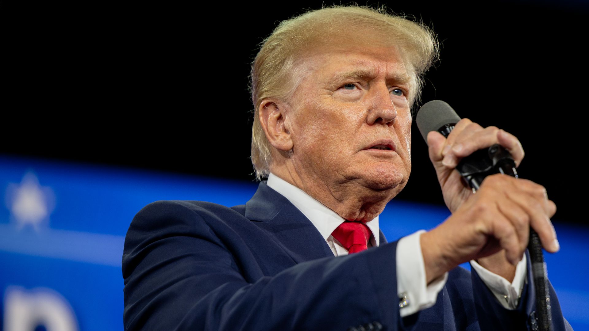 Photo of Donald Trump speaking into a mic