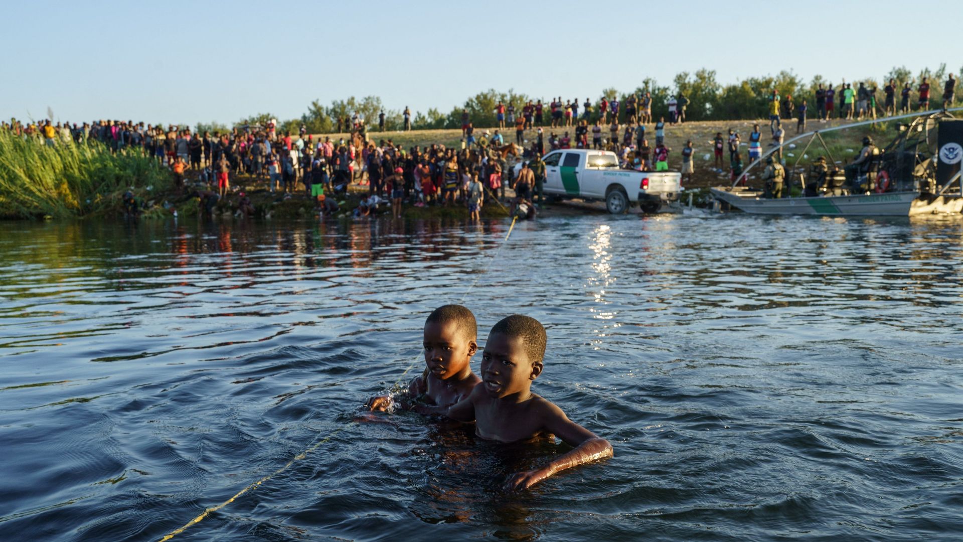 Picture of two Haitian boys in water crossing the U.S.-Mexico border