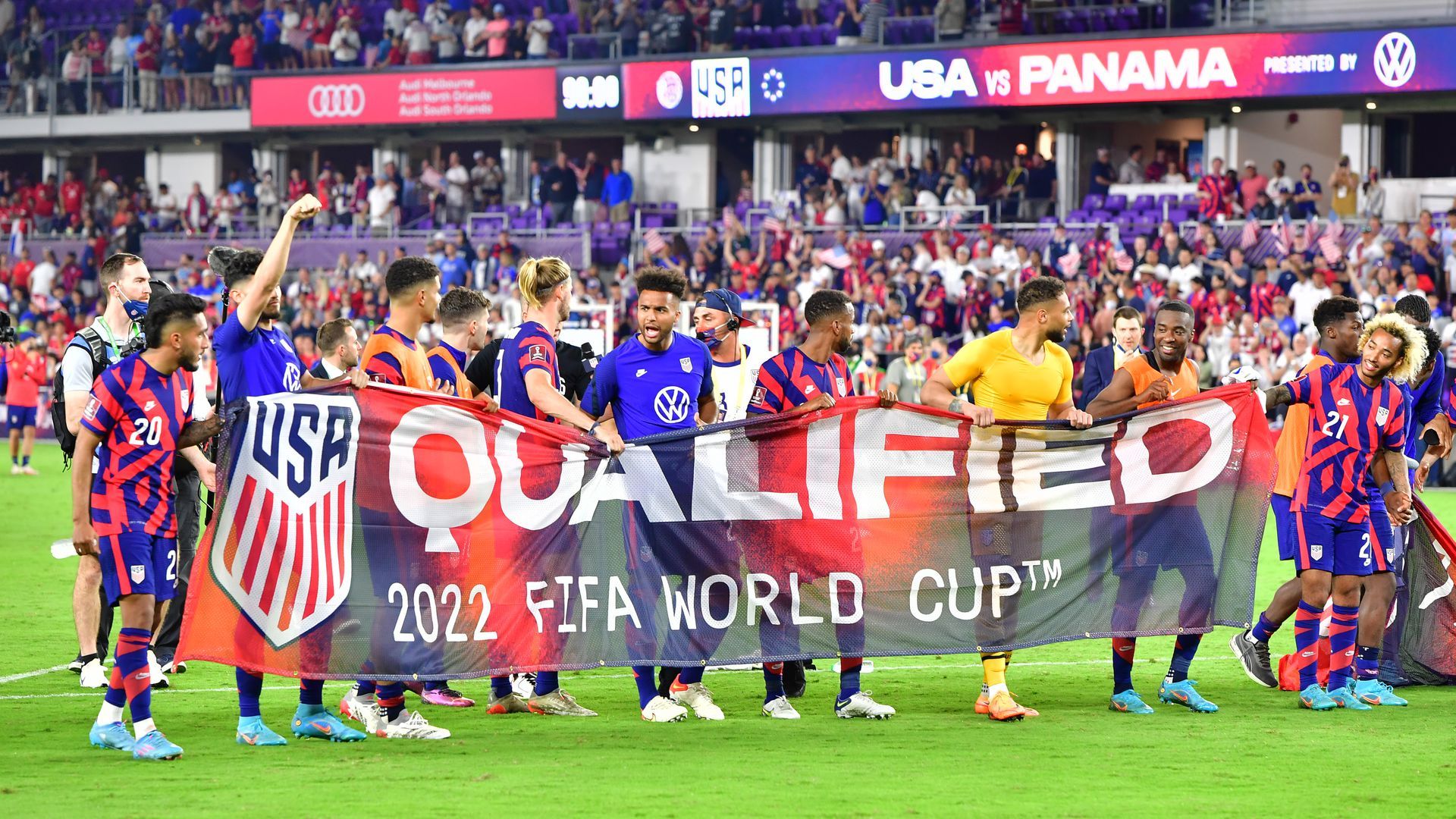 USMNT holds up a banner that reads, "Qualified."