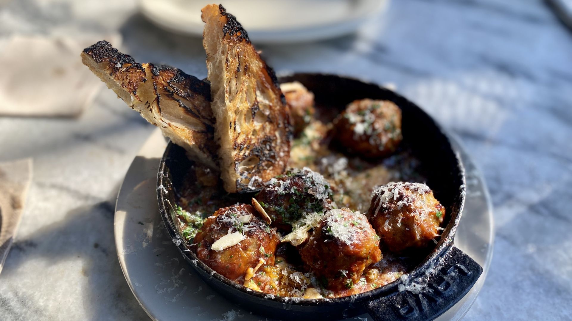 a bowl of meatballs with toast points sticking out