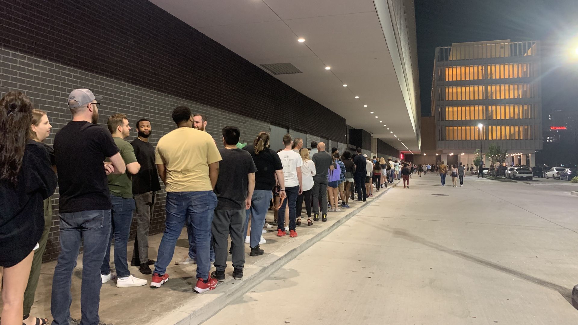 Photo of a lot of  people in a long line. 