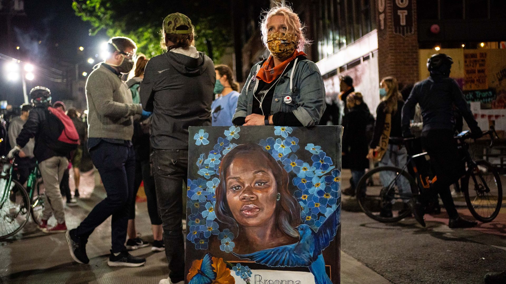 A demonstrator holds a painting of Breonna Taylor during a protest near the Seattle Police Departments East Precinct on June 7