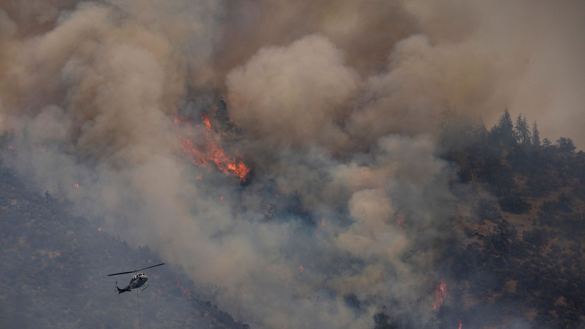 A helicopter flying near smoke and flames from the McKinney Fire in the Klamath National Forest near Yreka, California, on Aug. 2.