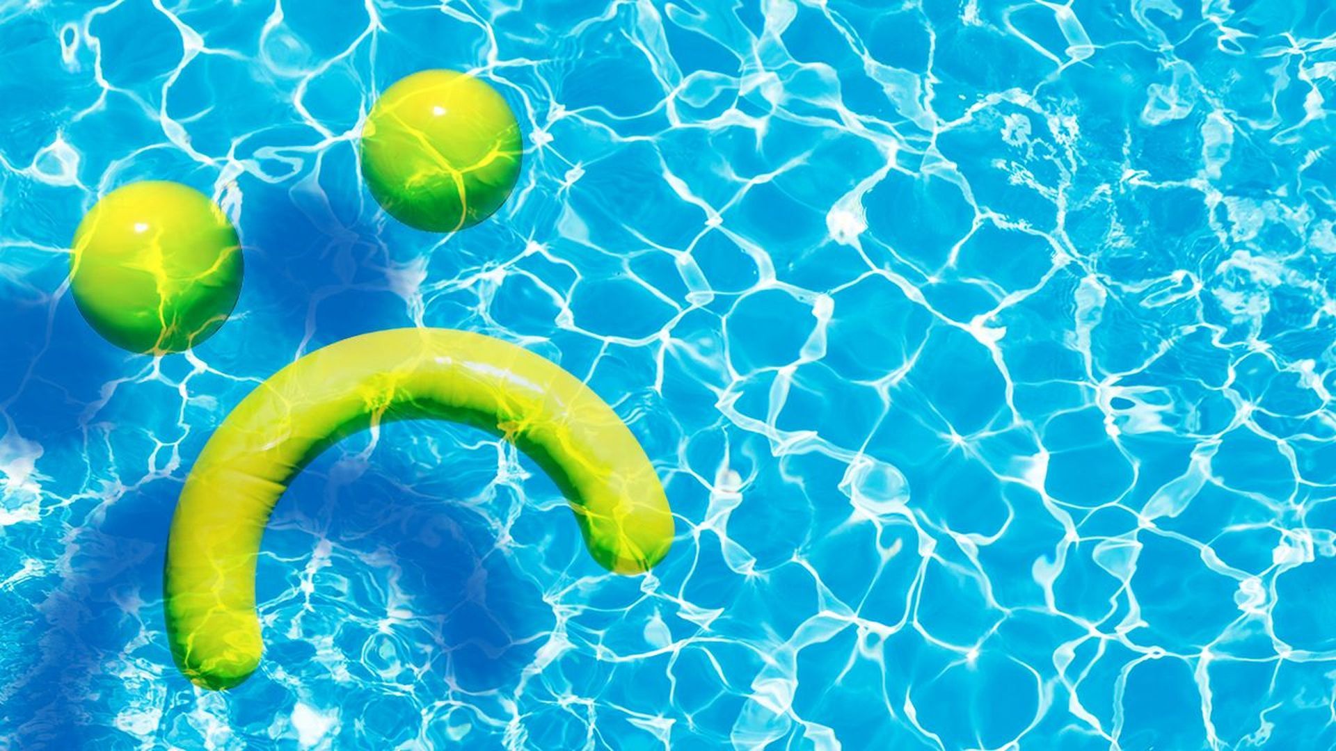 Swimming pool water with pool noodles in the shape of a sad face.