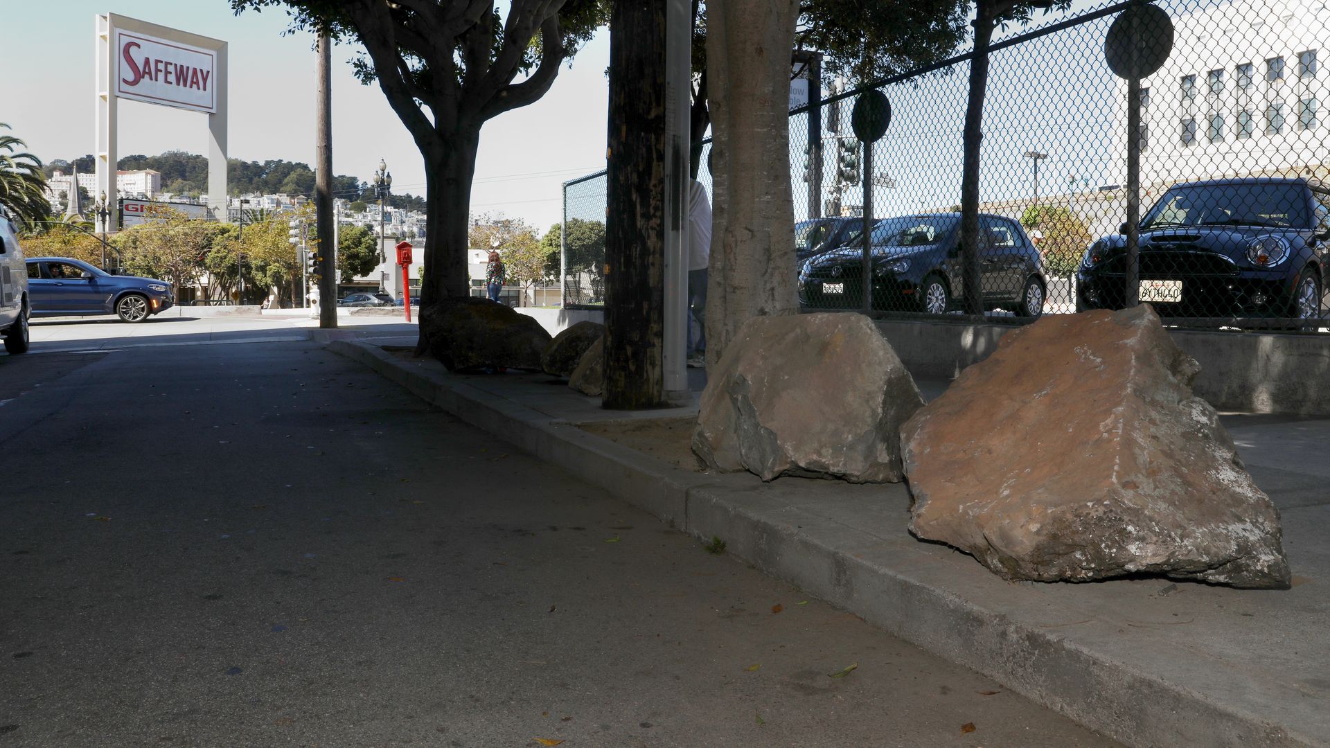 Photo of larger boulders sitting along a sidewalk