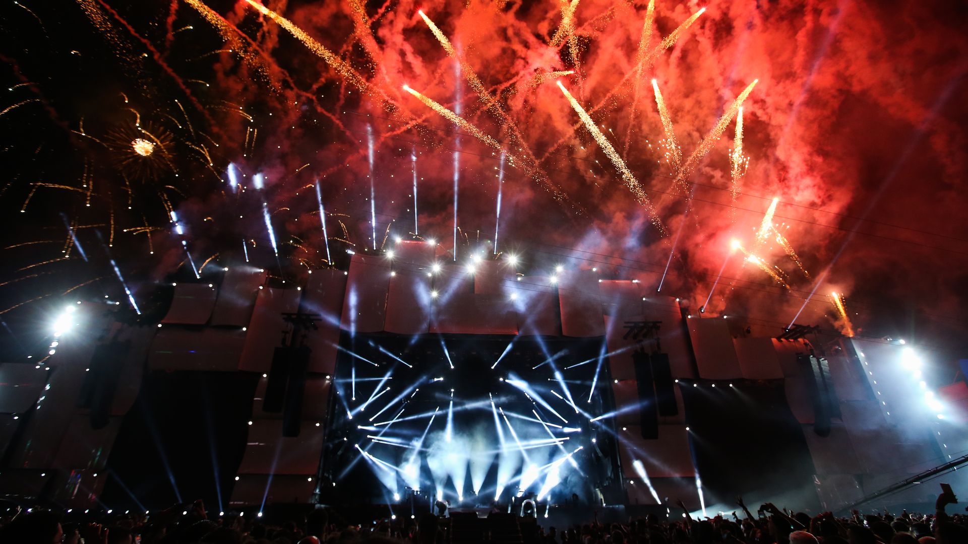 Photo of fireworks and a light show at an outdoor concert