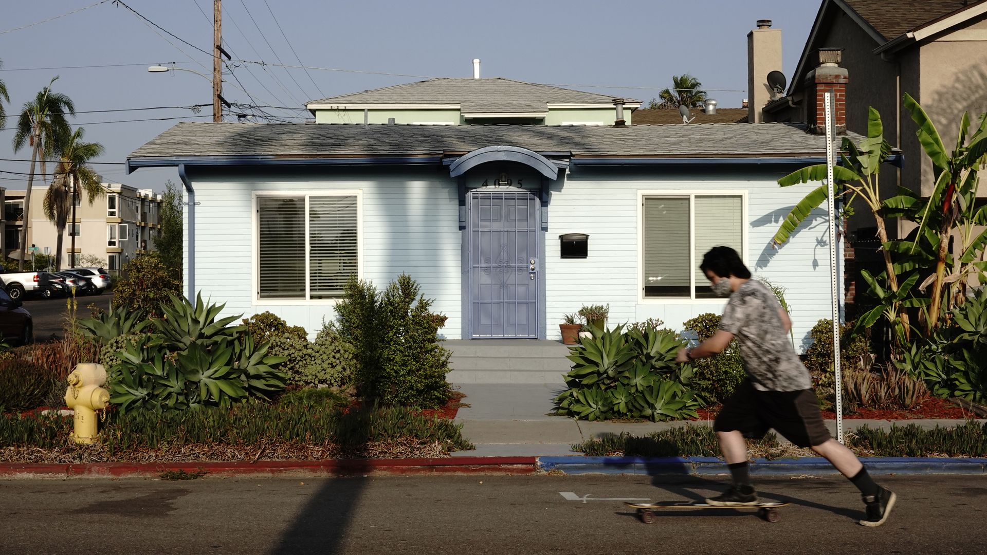 A North Park home with a man skateboarding in front of it