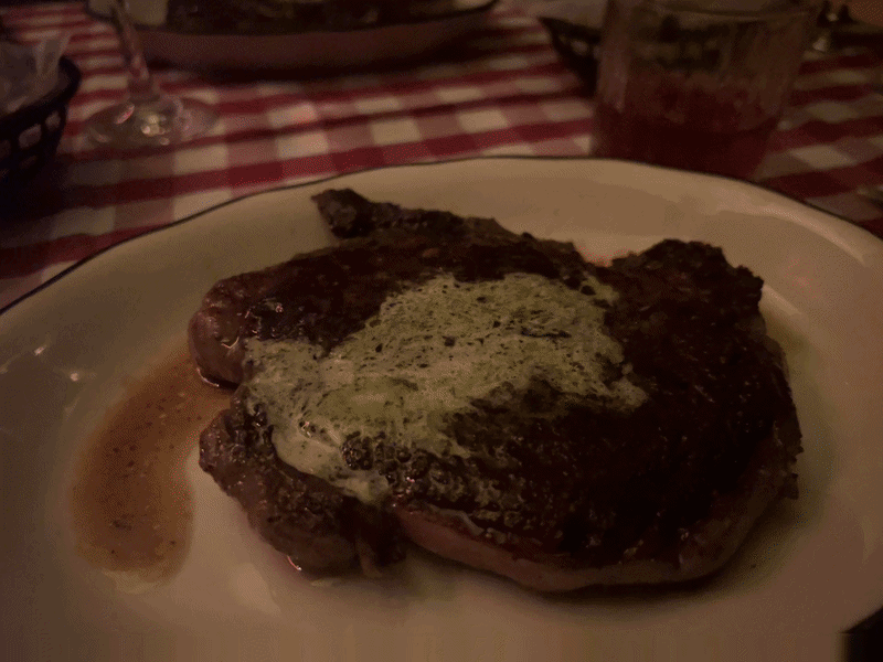 A gif of a live photo of a steak with the flash going off and the steak moving out of frame
