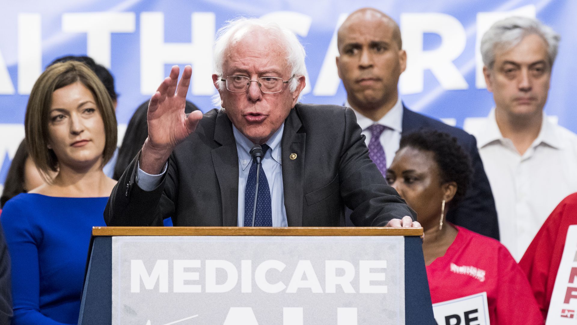 Bernie Sanders behind a Medicare for All lecturn