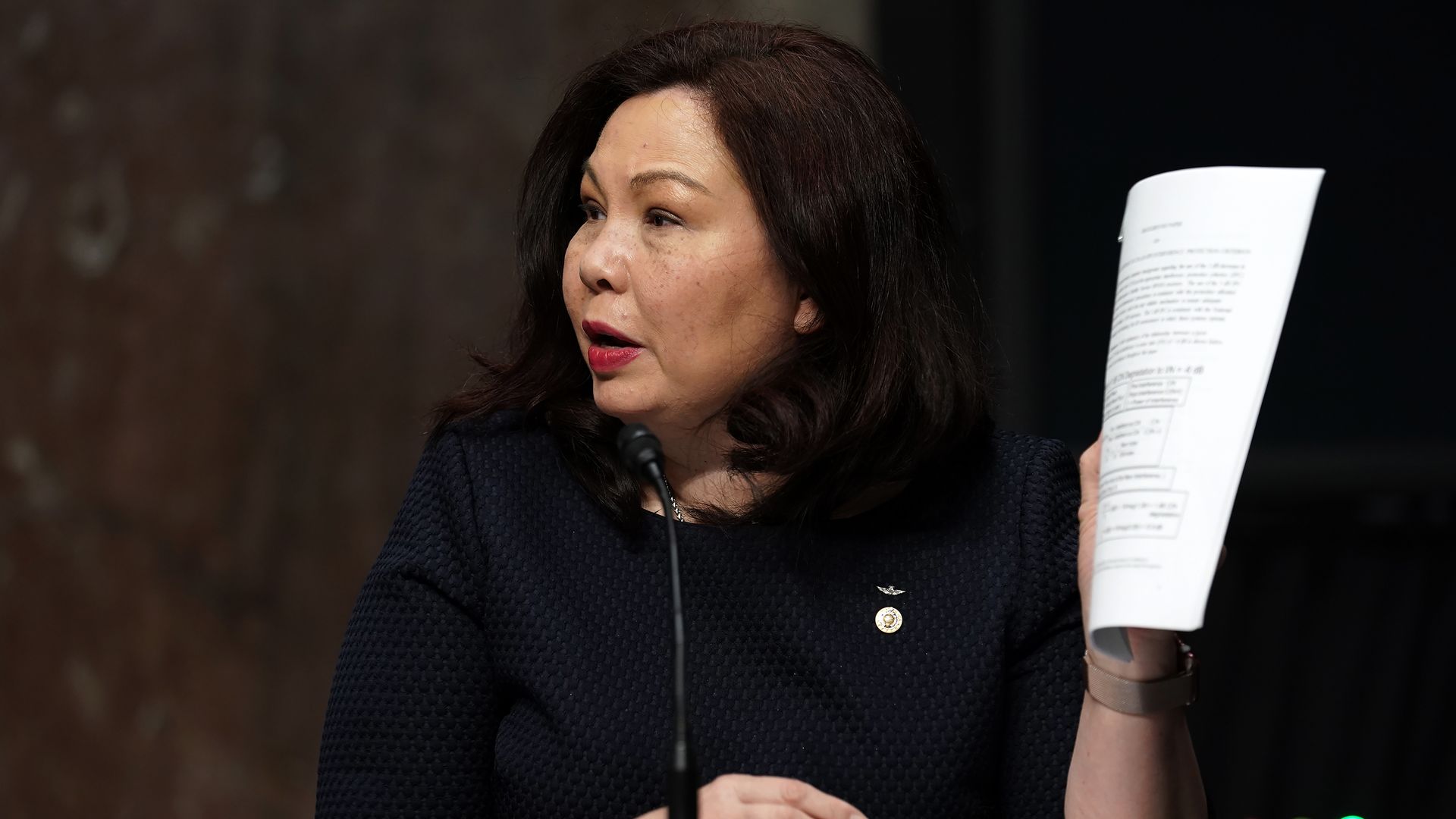 Sen. Tammy Duckworth holds a paper while speaking at a Congressional hearing