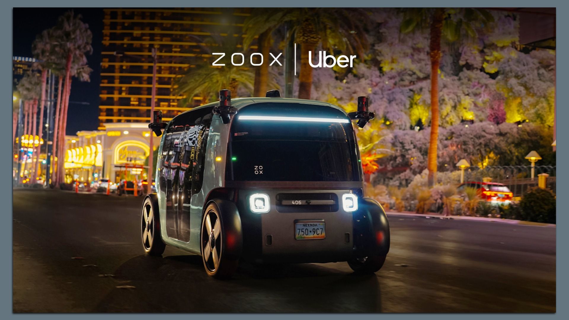 Night scene of a futuristic gray Zoox Uber robotaxi driving on a neon-lit city street in Las Vegas with palm trees and colorful storefronts.