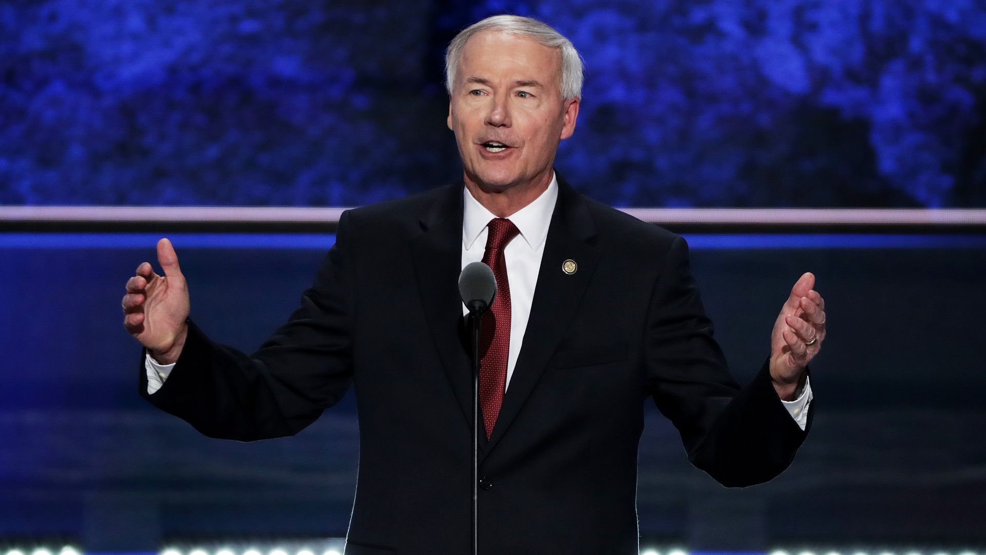 Gov. Asa Hutchinson wears a suit while gesturing
