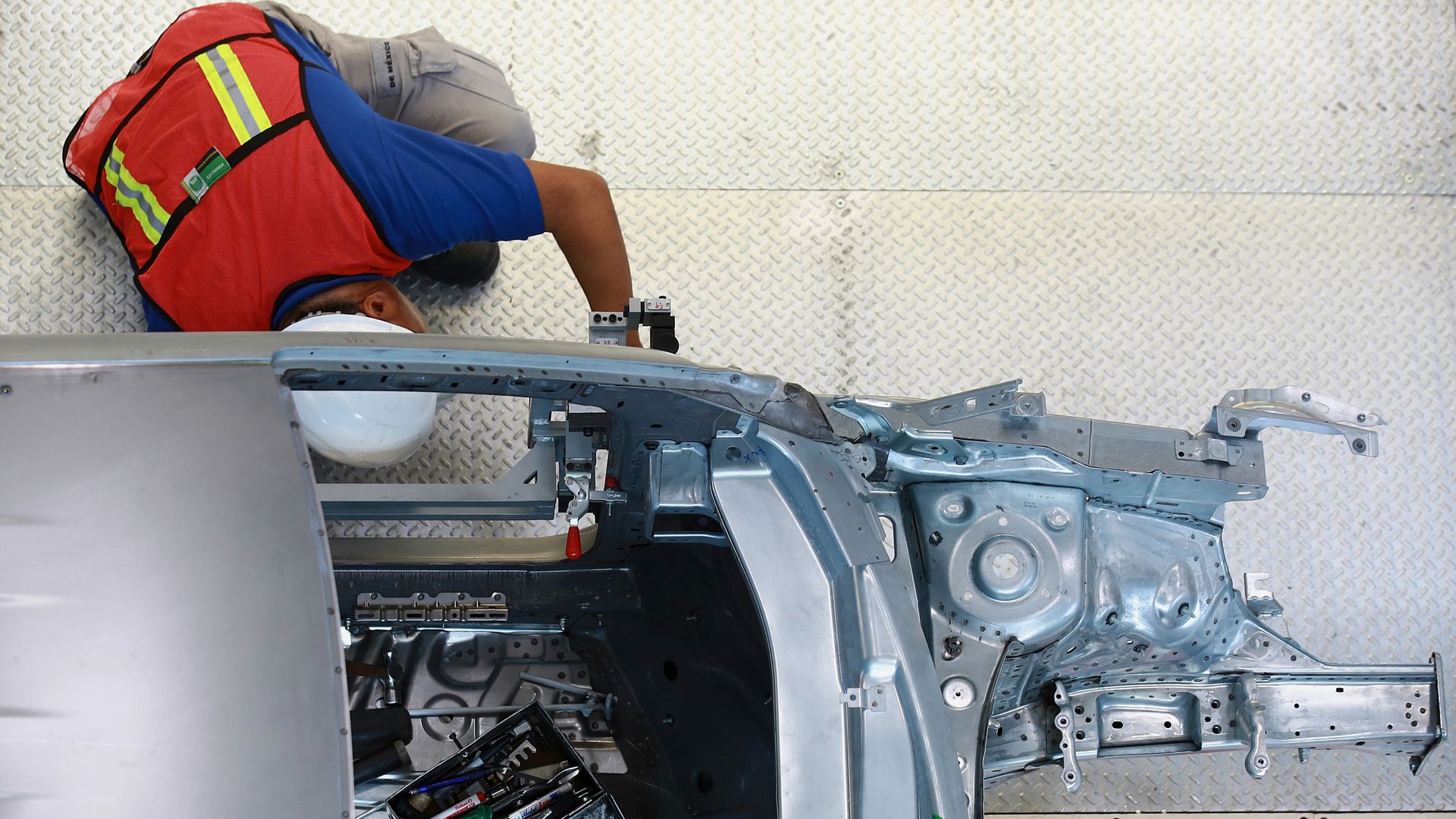 Employee works on test frame of car in Puebla, Mexico.