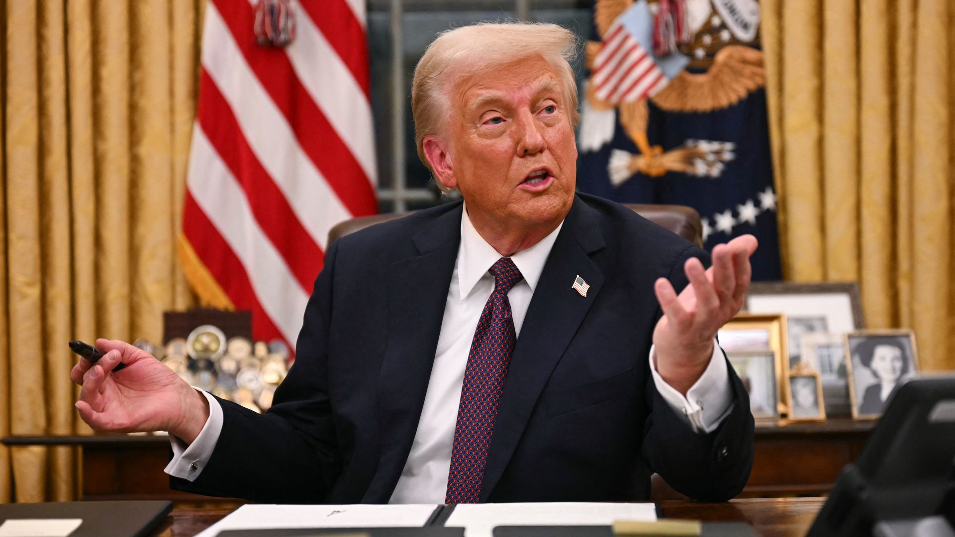 President Donald Trump speaks to journalists as he signs an executive order regarding Department of Government Efficiency (DOGE), in the Oval Office of the White House in Washington, DC, on January 20, 2025. 