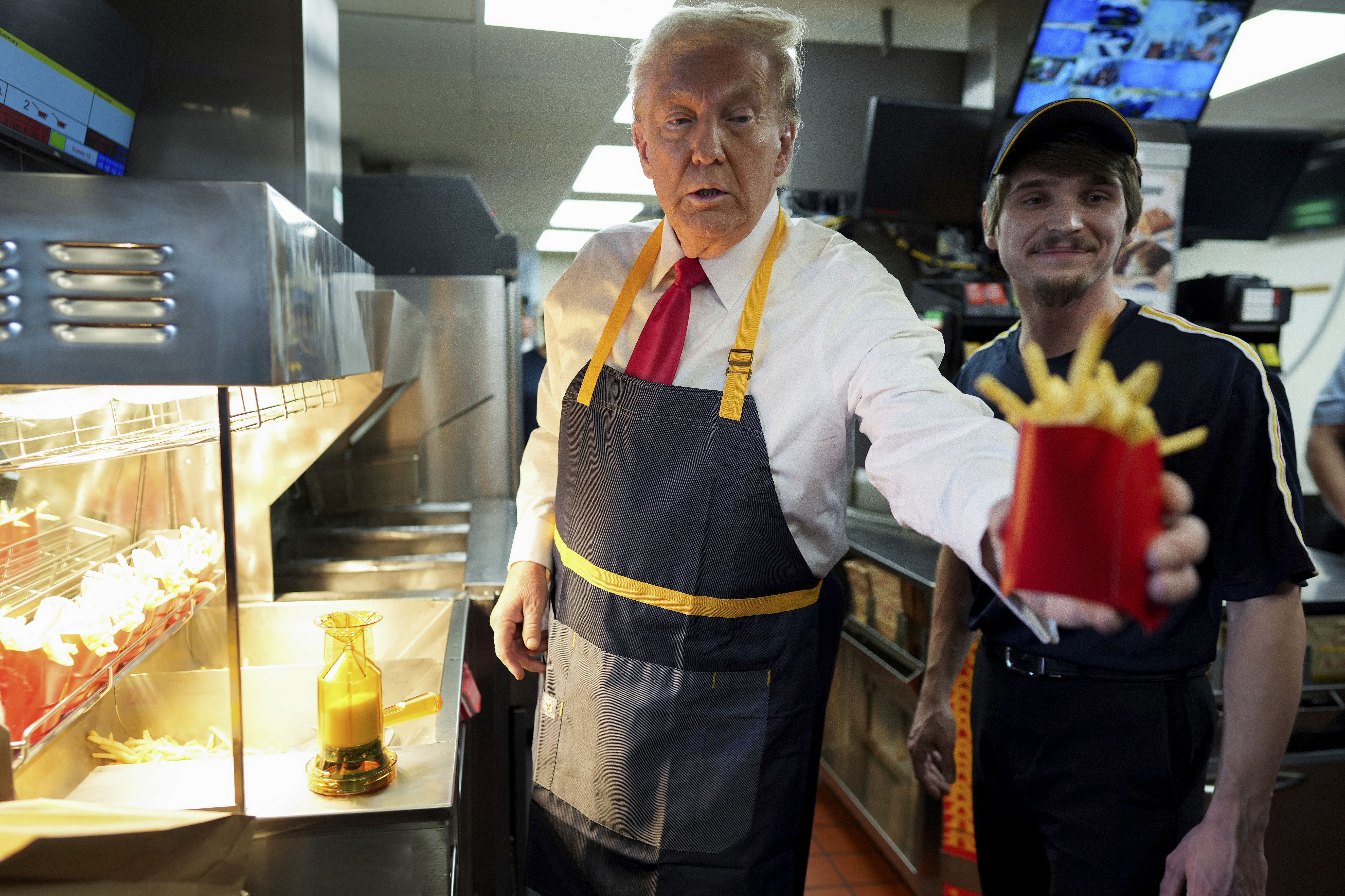 Former President Trump hands off an order of fries during a visit yesterday to a McDonald's in Feasterville-Trevose, Pa.,