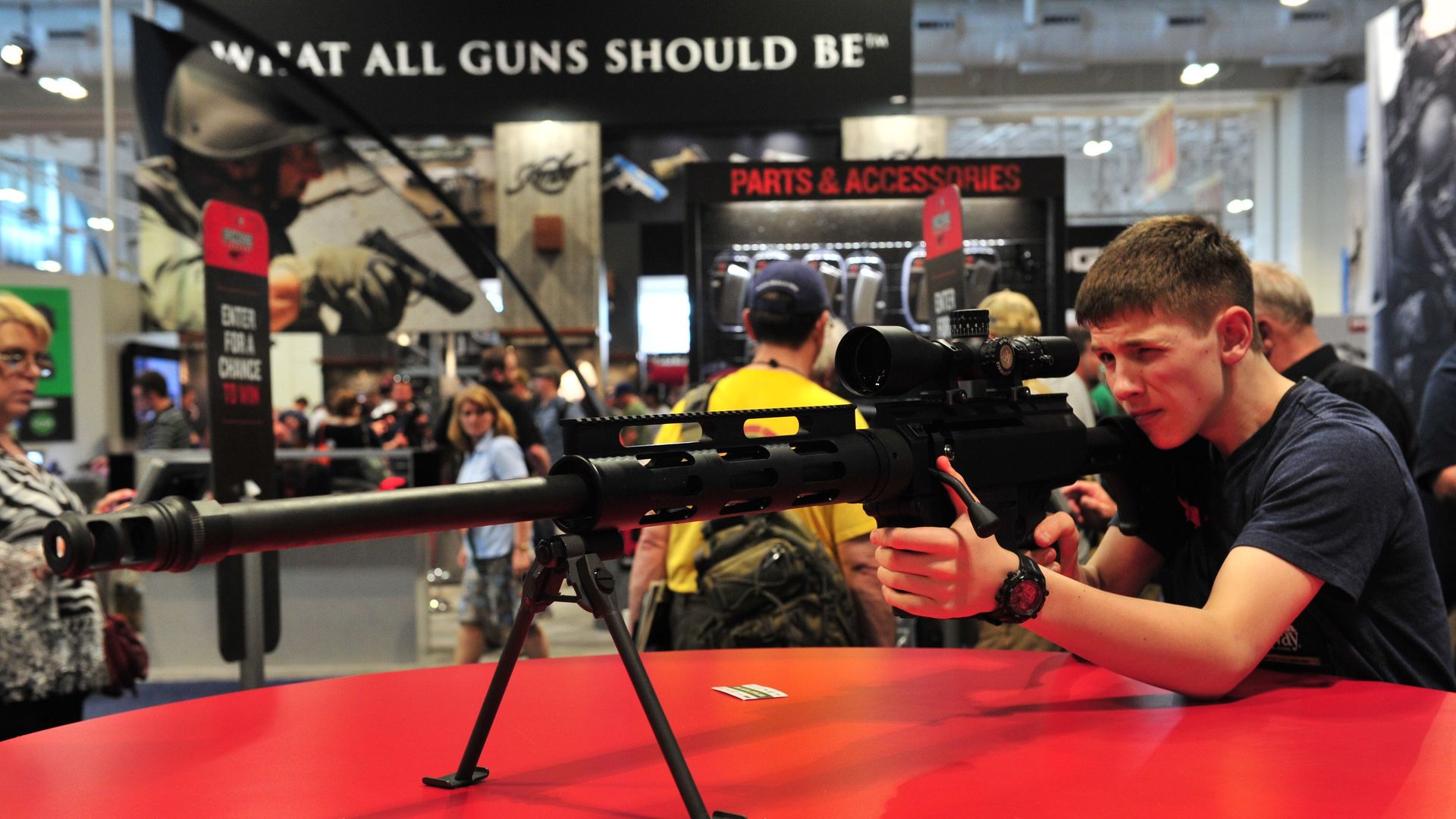 Man tries out Bushmaster rifle at gun show.