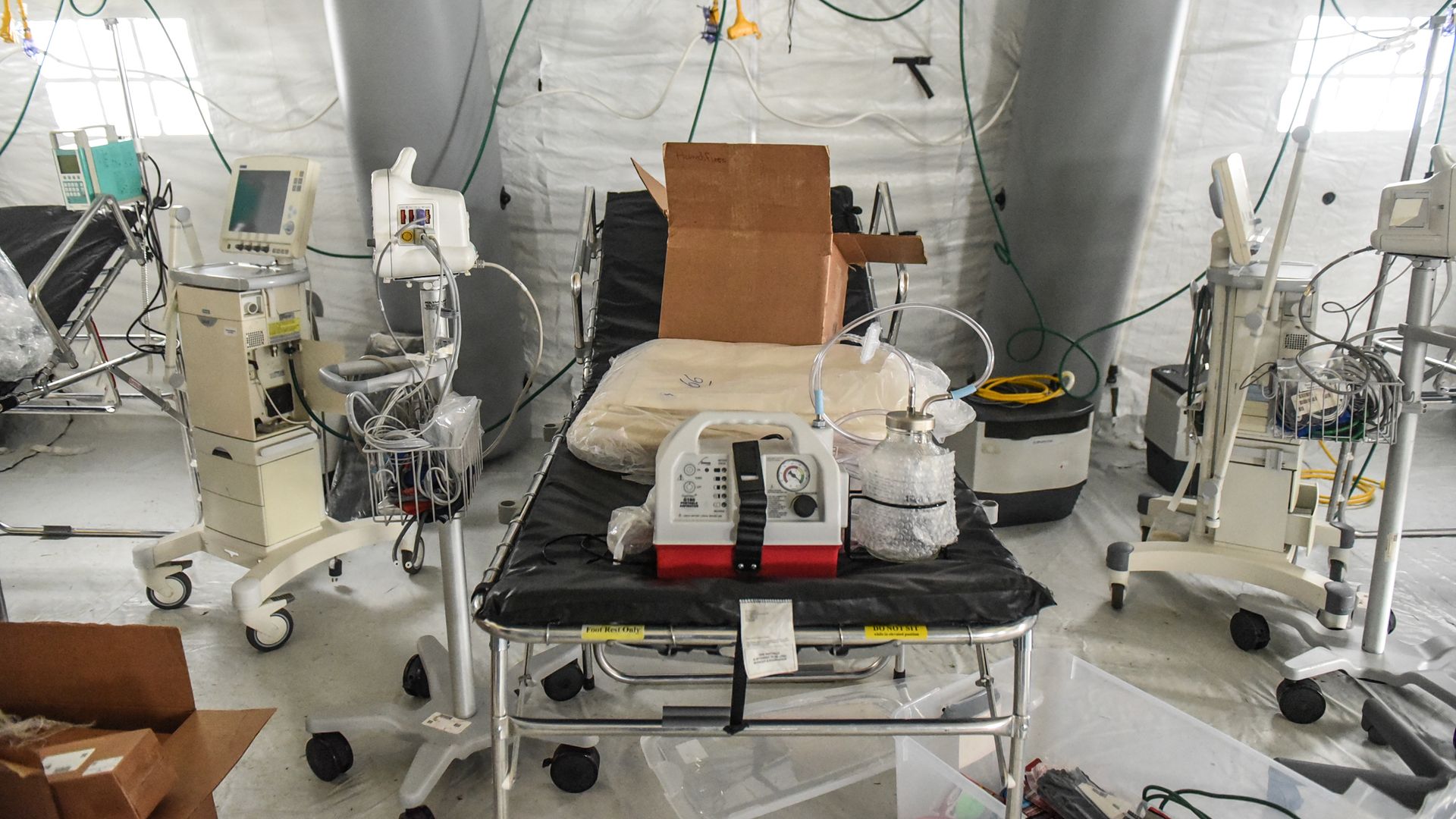 In this image, a ventilator sits on a gurney 