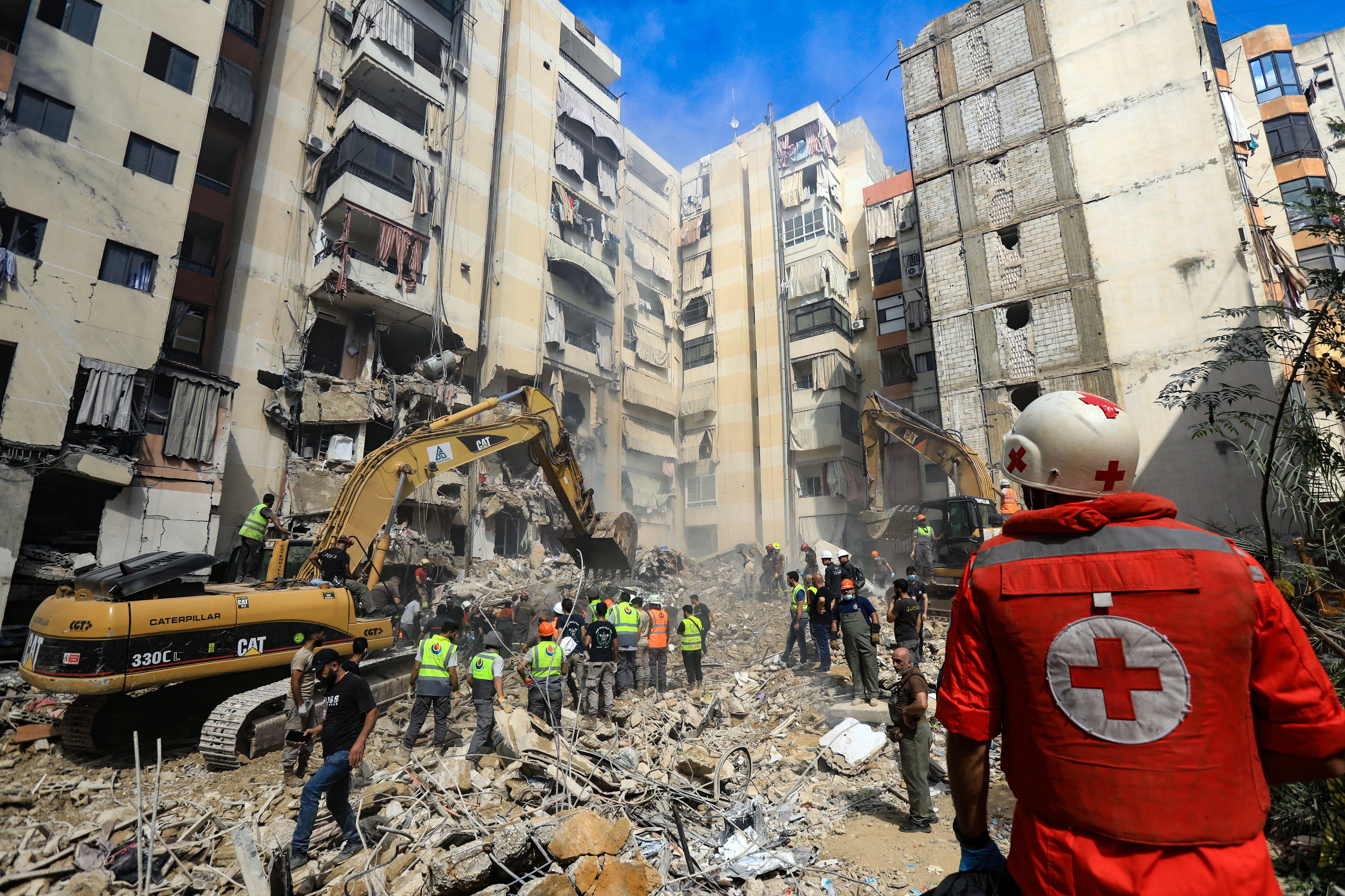 Rescuers gather near a collapsed building in Beirut searching for suvivors.