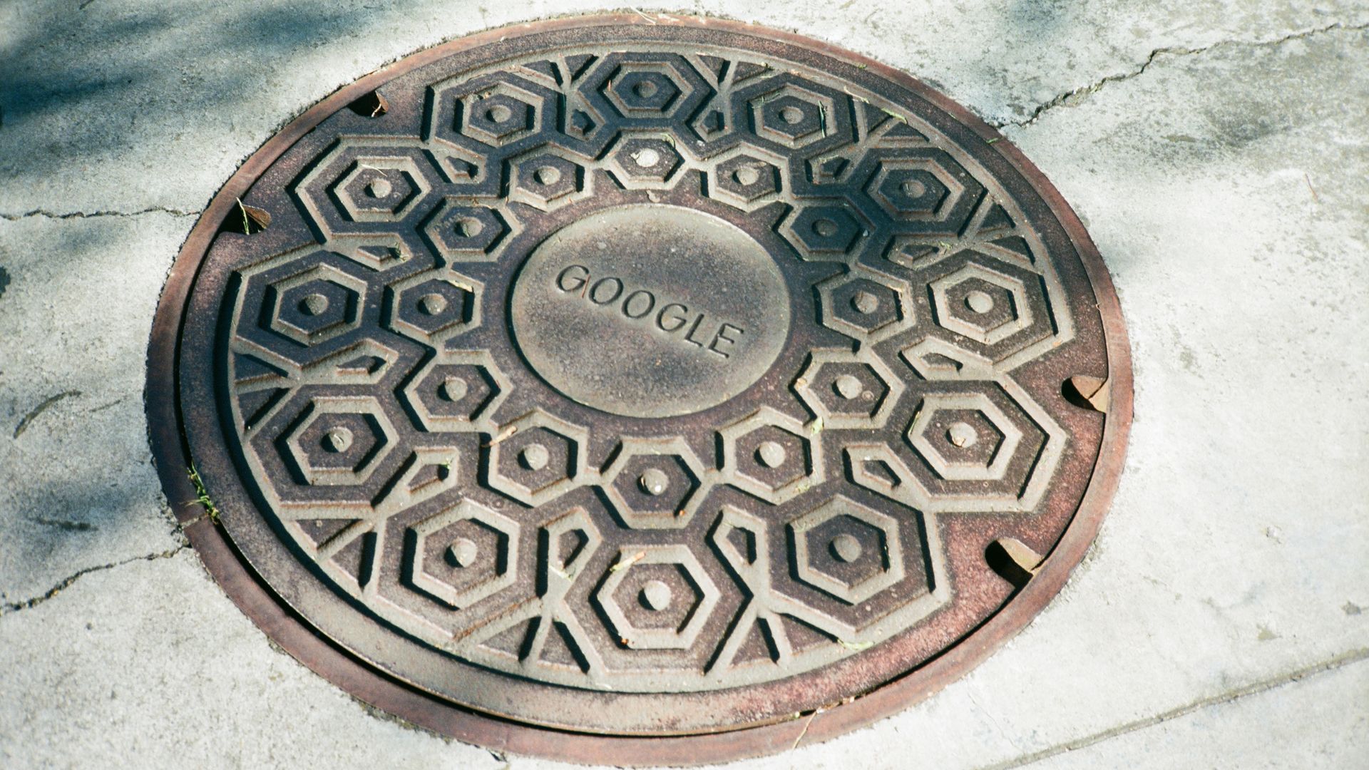 Photo of a manhole cover that says "Google" at its center
