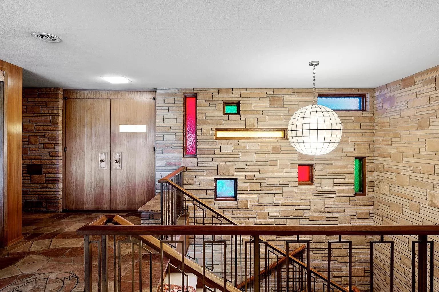 A foyer with unique colored windows.