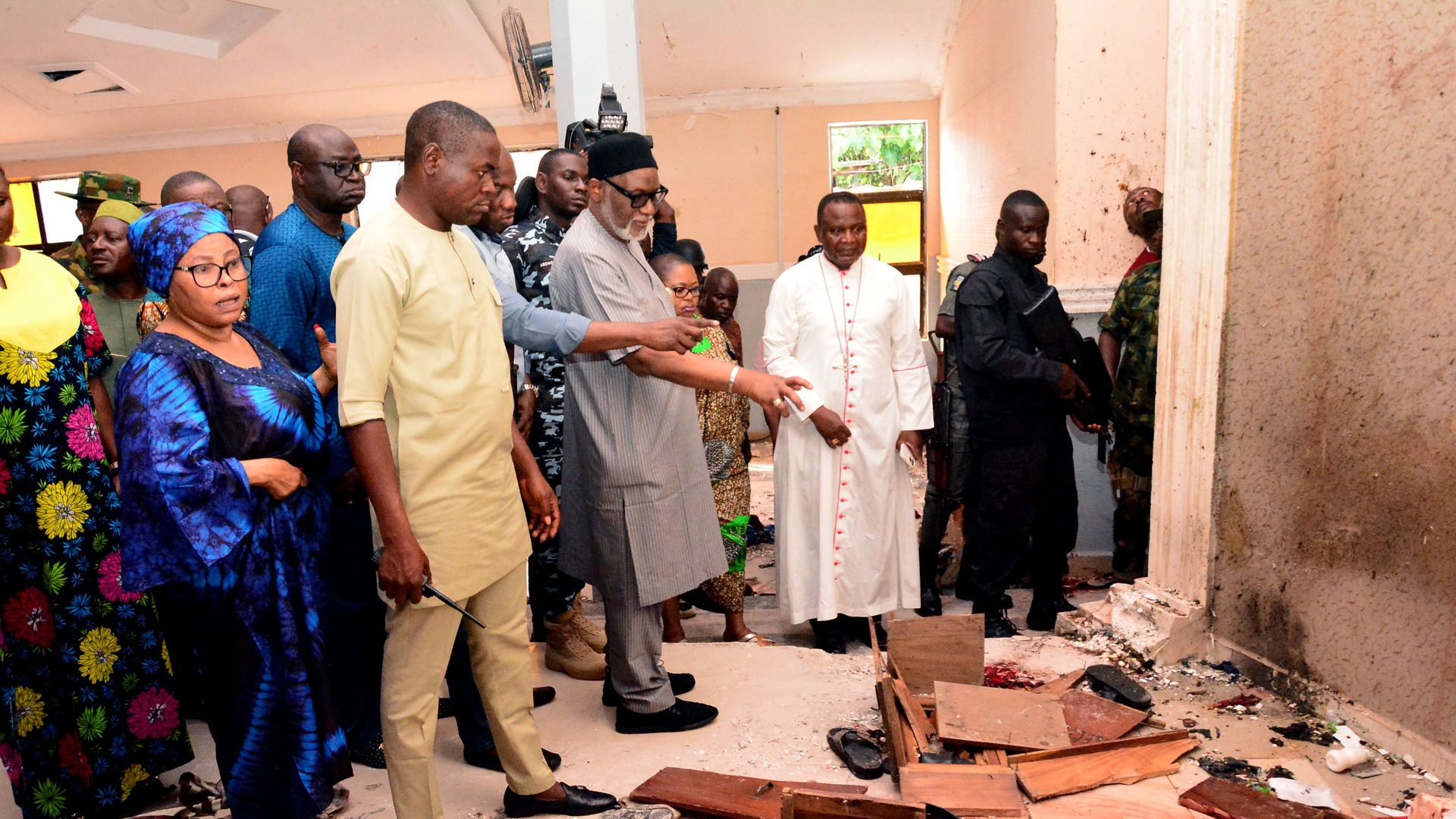 - Ondo State governor Rotimi Akeredolu (3rd L) points to blood the stained floor after an attack by gunmen at St. Francis Catholic Church in Owo town,