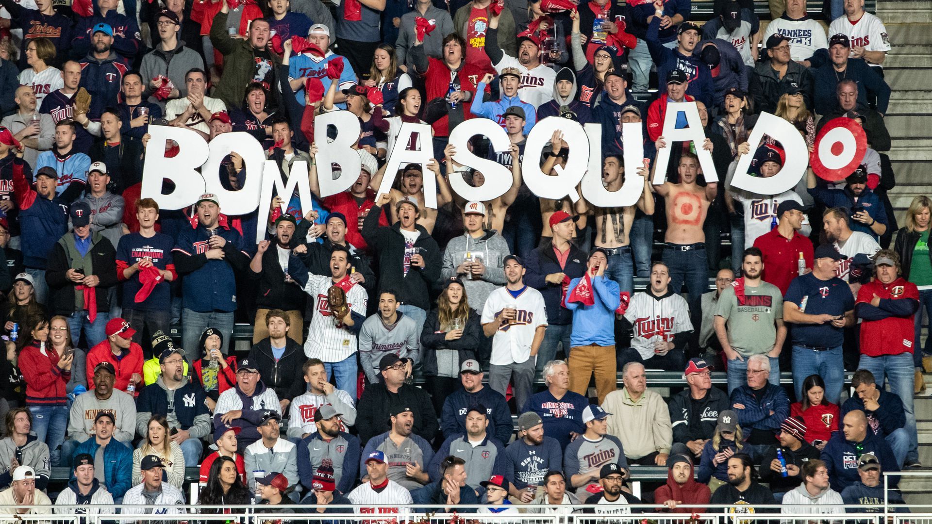 Minnesota Twins fans hold up letters spelling out Bombsquad at a game