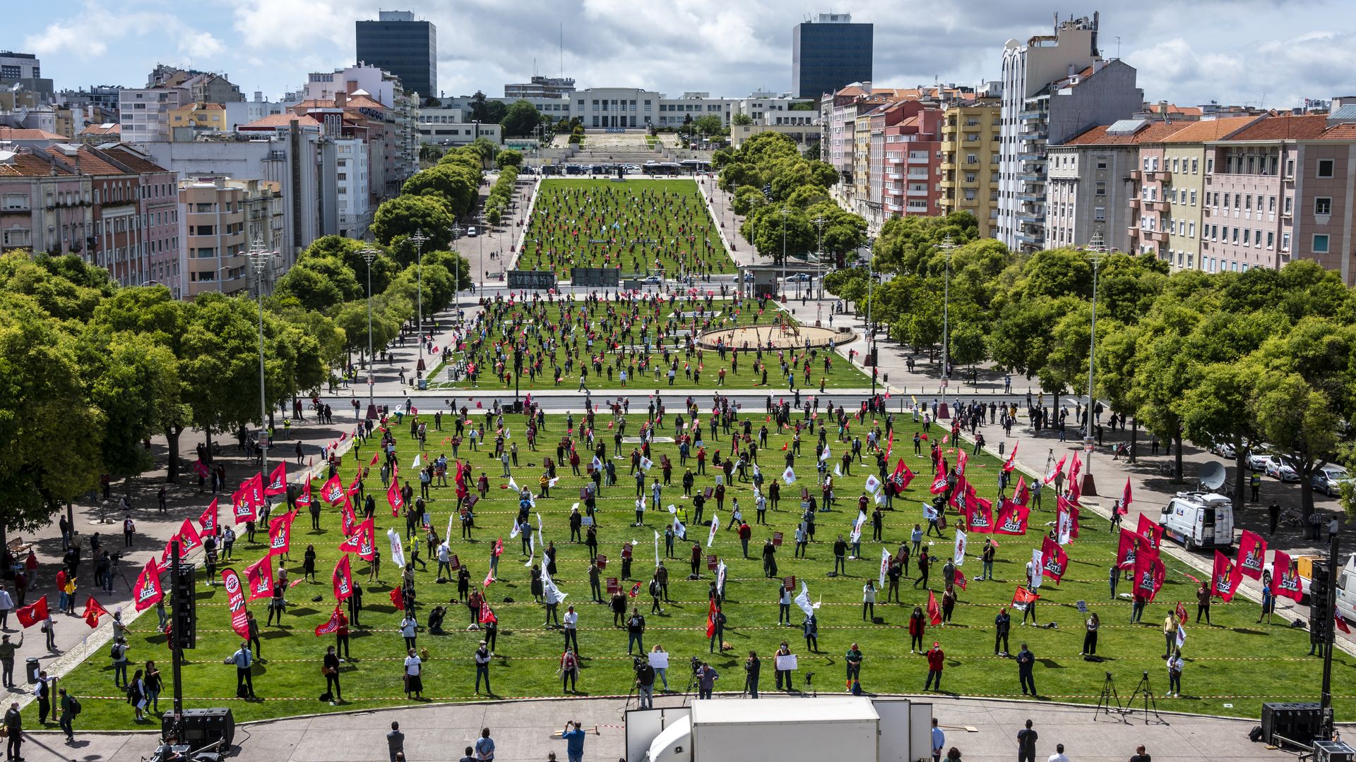 In this image, a wide field shows protestors socially distancing while standing 