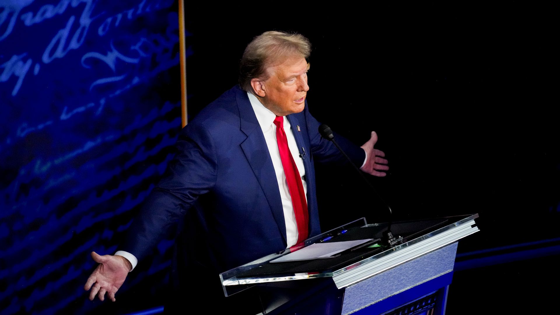 Former President Trump speaks from behind a podium at the ABC presidential debate against Vice President Harris.